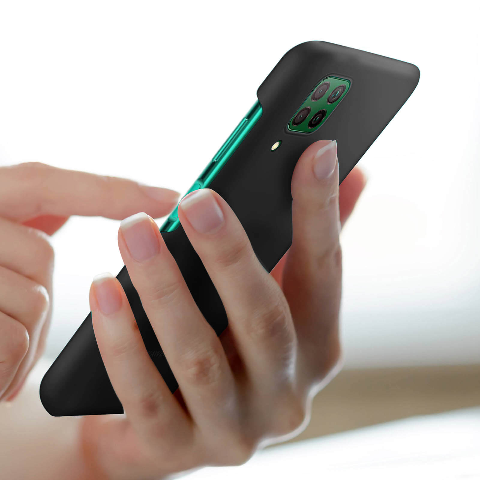 Une main tient une coque de téléphone noire. Le téléphone est dans un environnement blanc et bien éclairé.