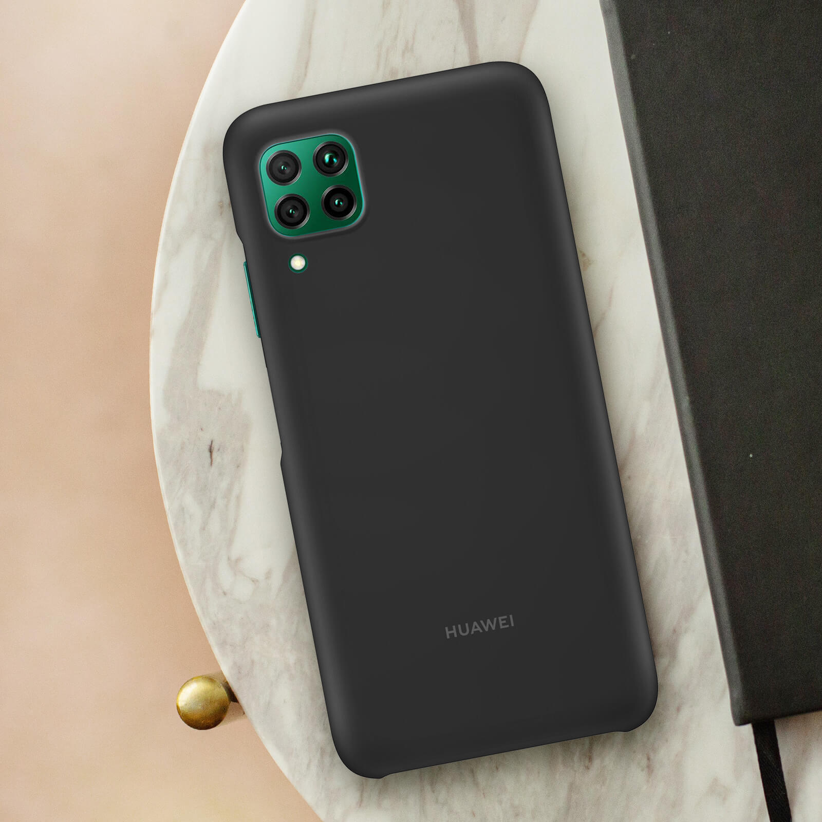 Coque noire avec module caméra vert posée sur une surface en marbre.