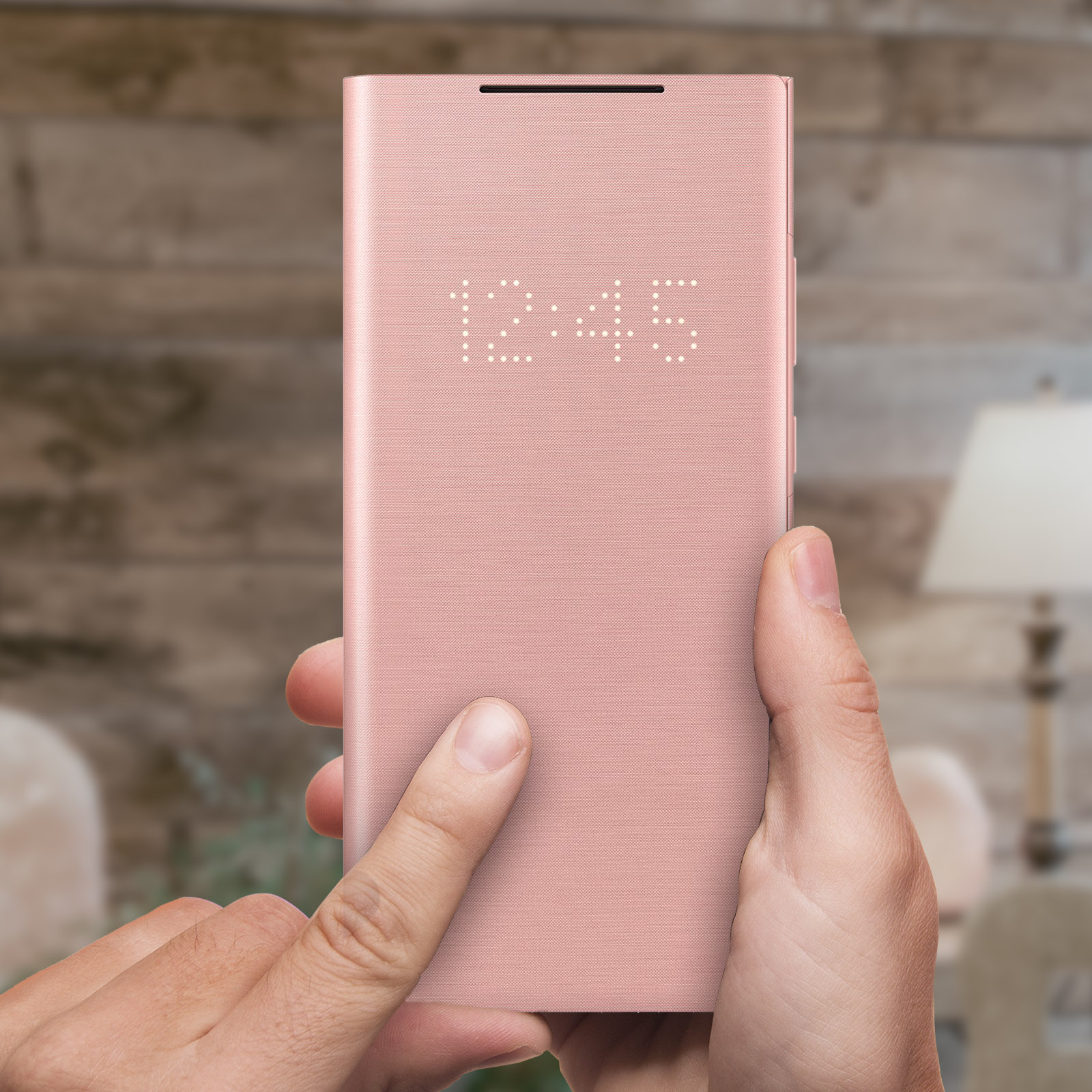 Una custodia rosa per telefono che mostra l'ora, con una mano che tocca lo schermo.