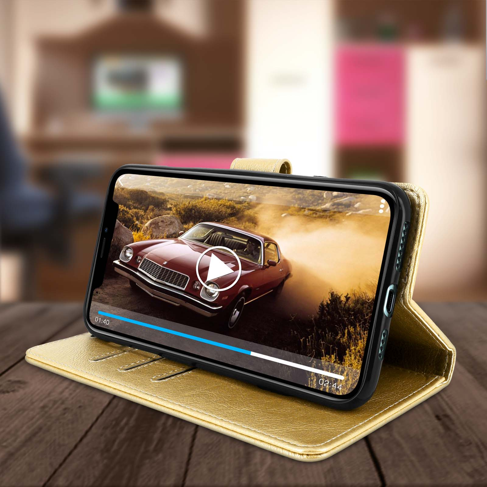 Un téléphone sur un étui doré, ouvert et affichant une vidéo d'une voiture rouge en mouvement. Une table en bois au premier plan.