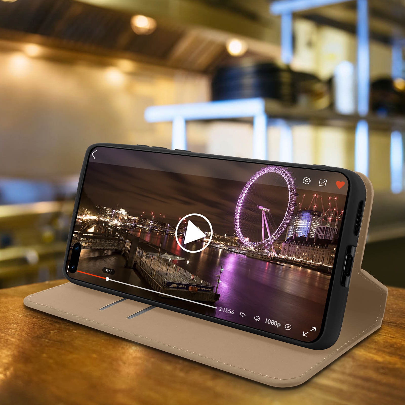 Téléphone dans un étui lit une vidéo du London Eye. Sur une table en bois.