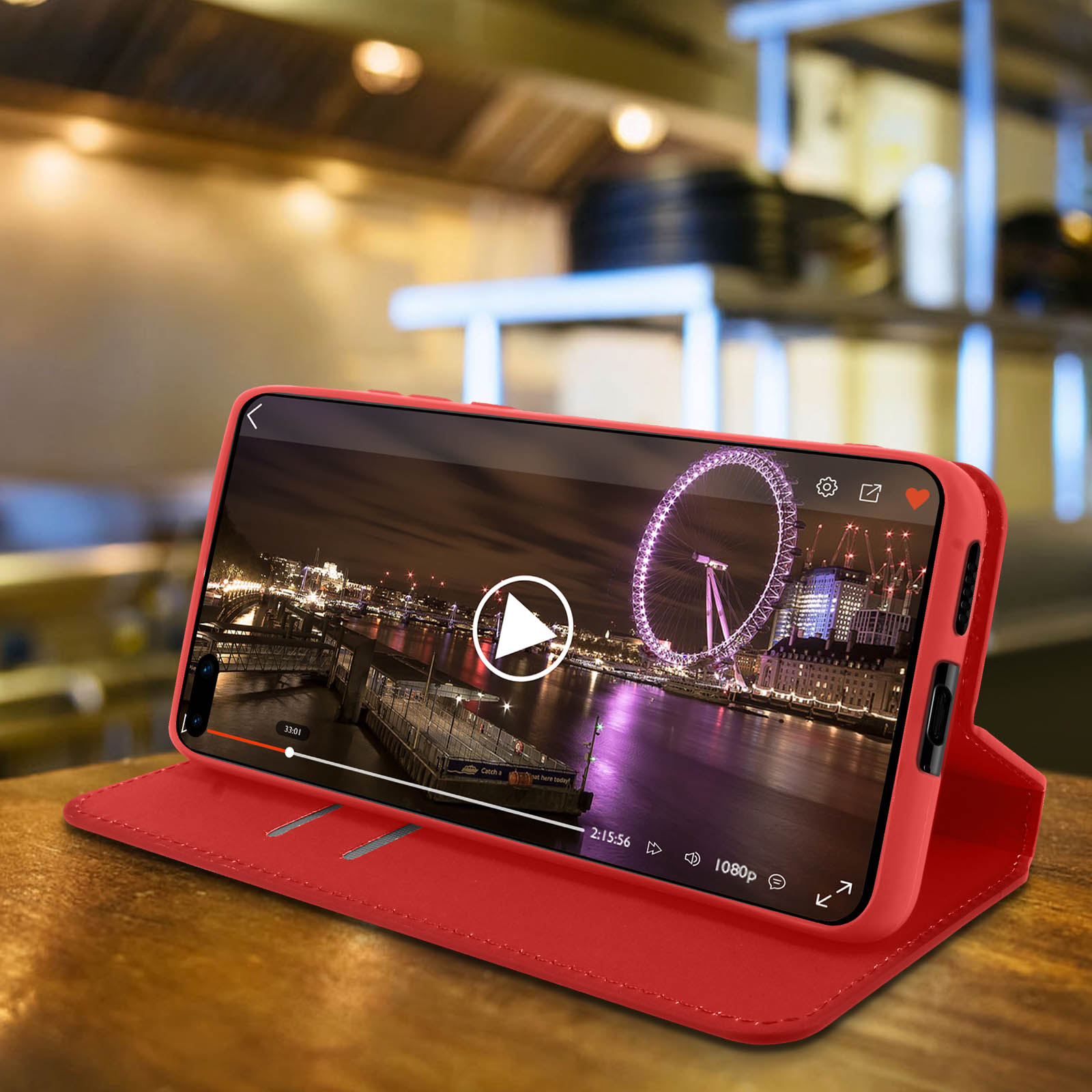 Custodia rossa con telefono che riproduce un video. Il London Eye sullo sfondo.