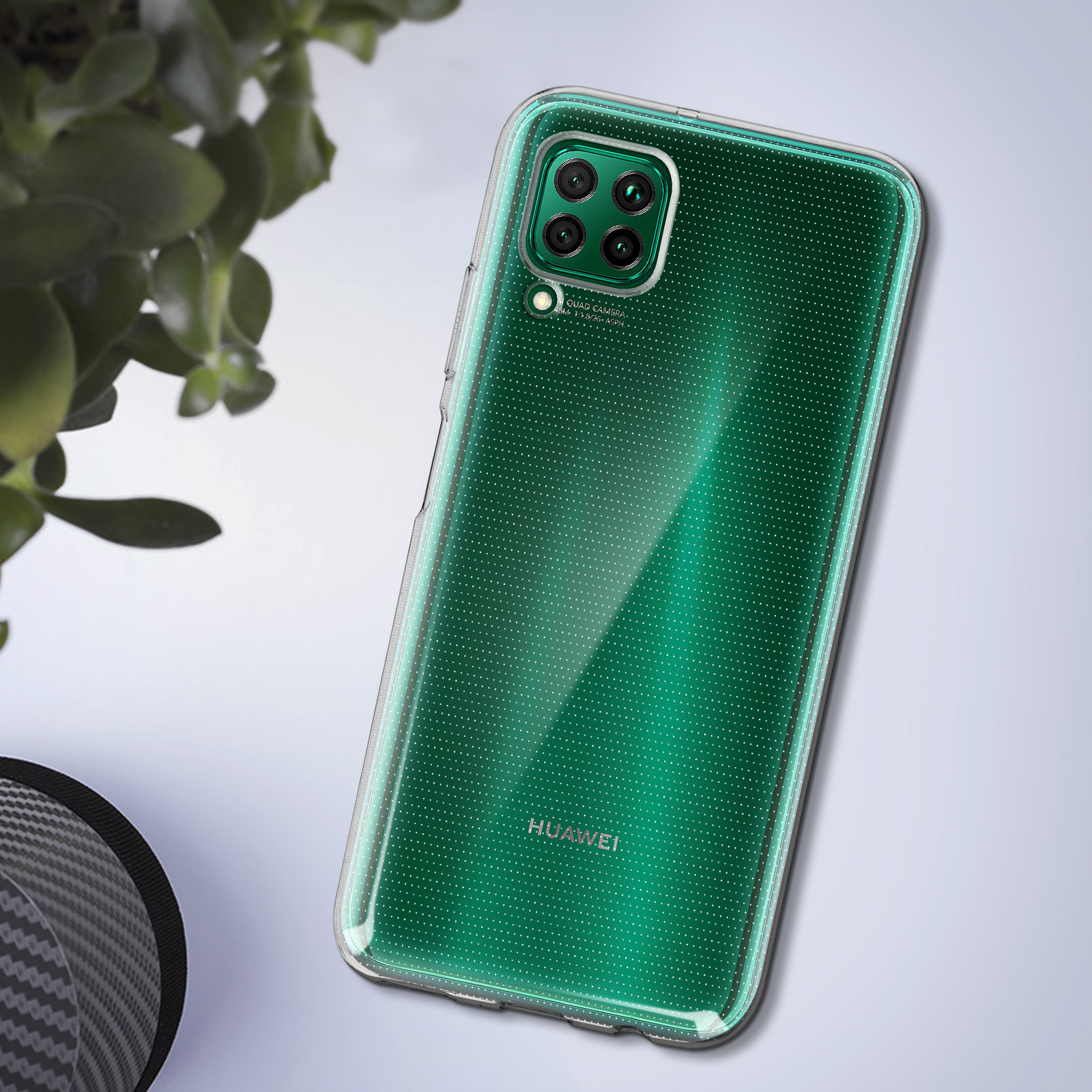 Una custodia trasparente su un telefono con sfondo verde. Foglie sullo sfondo.