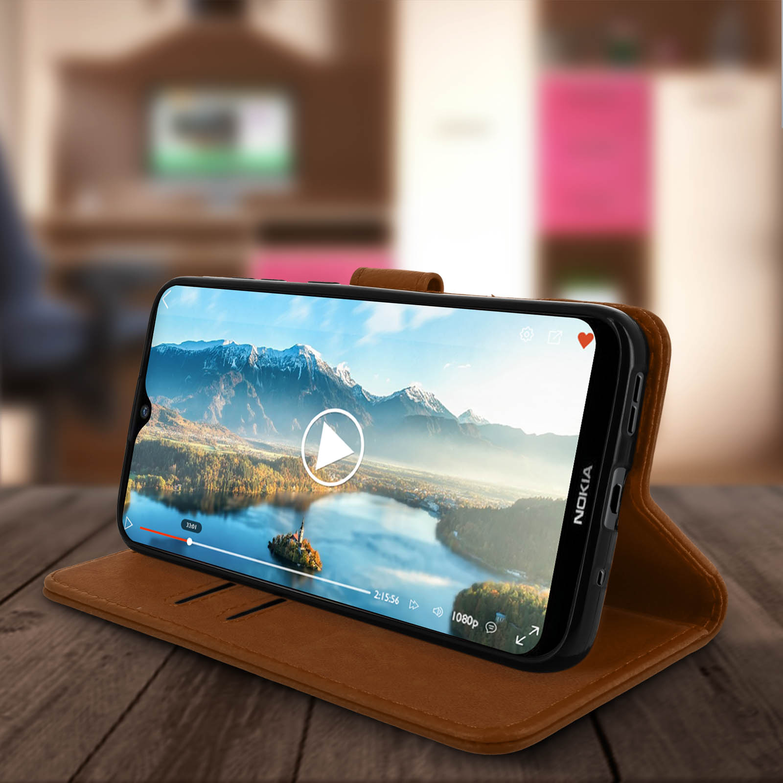 Telefoon in een bruine hoes speelt een video af op een houten tafel. Achtergrond is wazig.