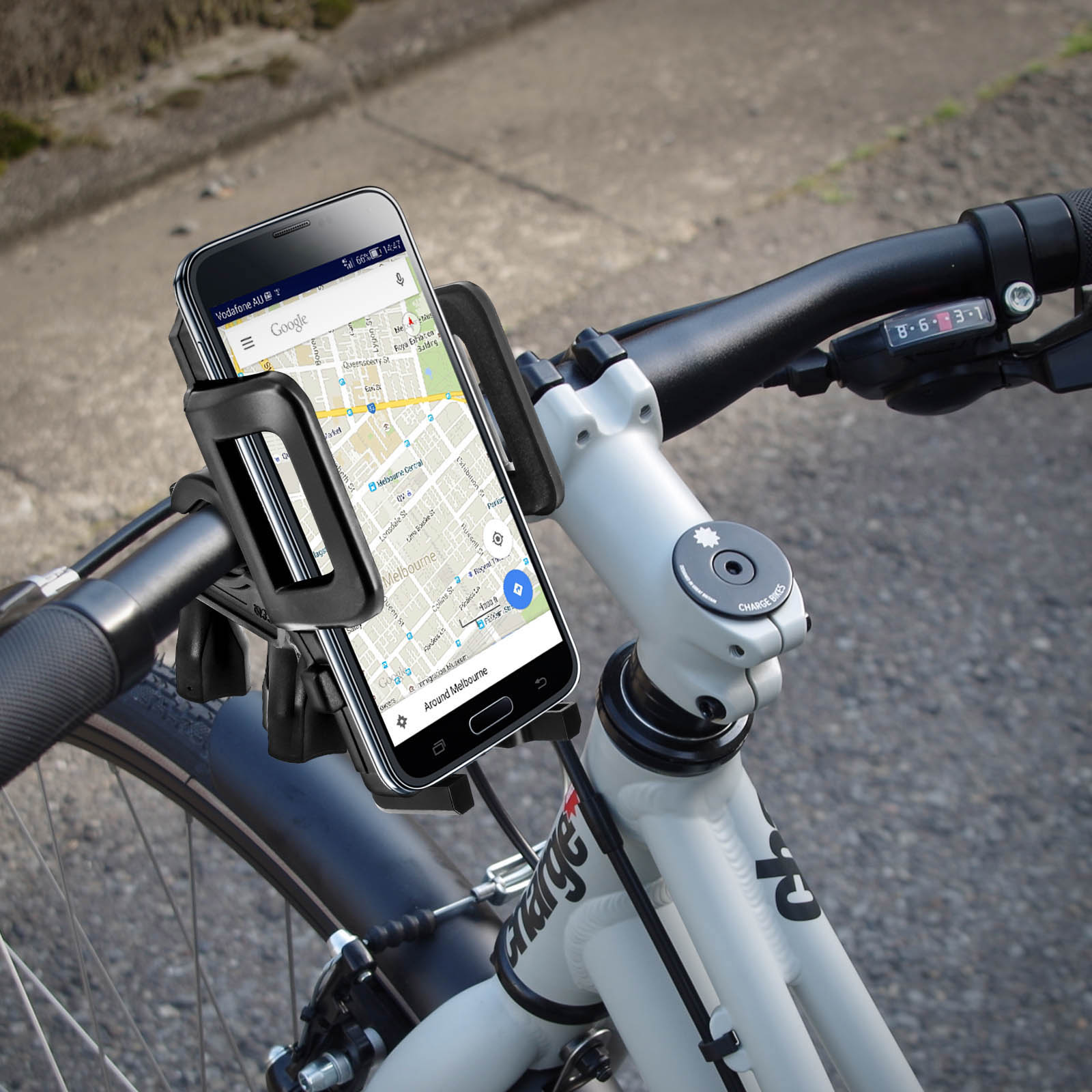 Telefono montato sul manubrio della bici mostra una mappa. La bici è su superficie pavimentata.