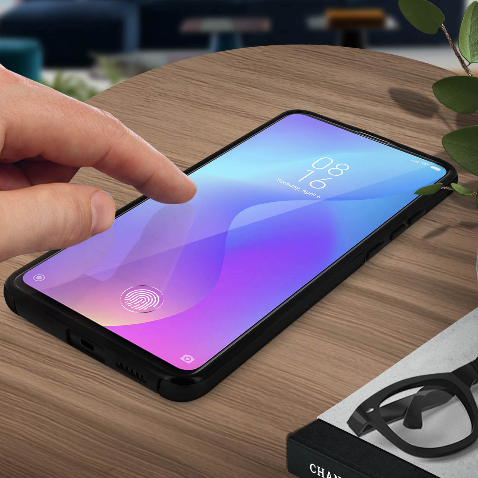 Una mano tocca lo schermo del telefono. Il telefono mostra la data: 6 aprile, martedì. Lo sfondo è un tavolo di legno.