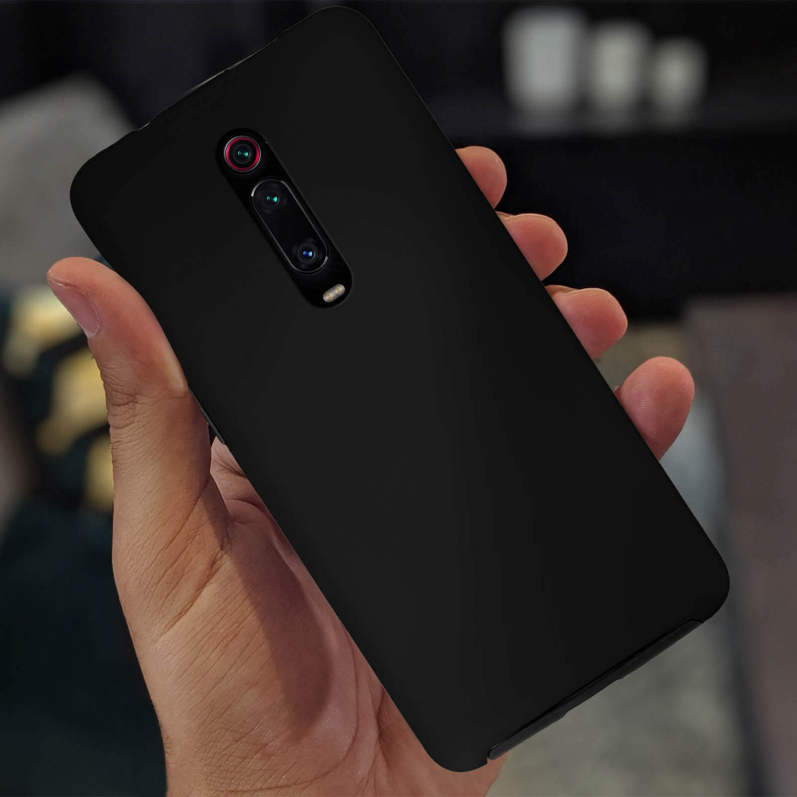 Una custodia nera per telefono tenuta in mano, che mostra il modulo della fotocamera.