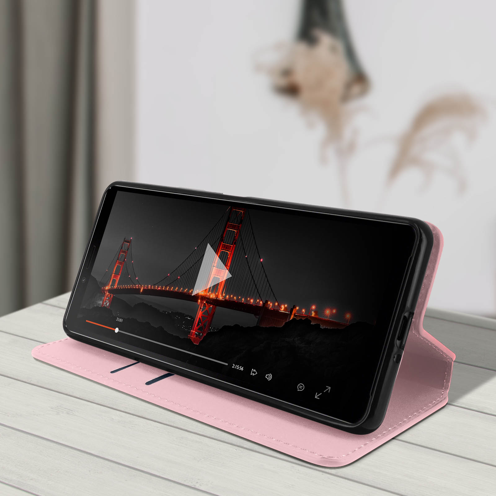 Un telefono su una custodia rosa mostra un video del Golden Gate Bridge.