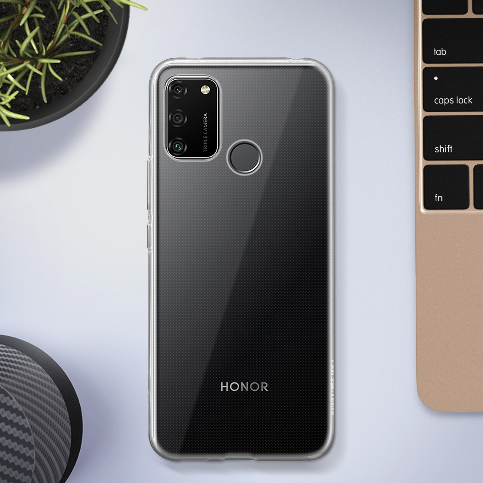 Coque de téléphone transparente sur une surface blanche avec un clavier et une petite plante.