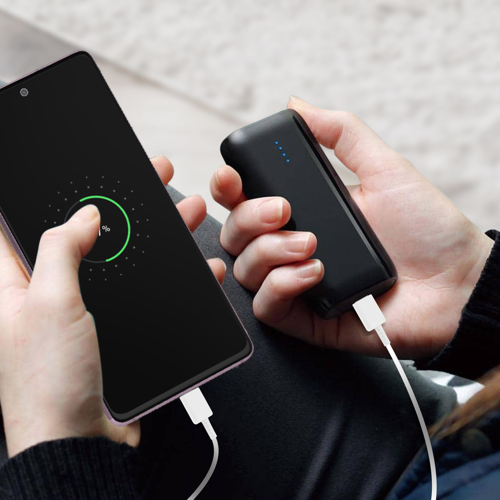 Telefono in carica wireless, collegato a power bank nero.