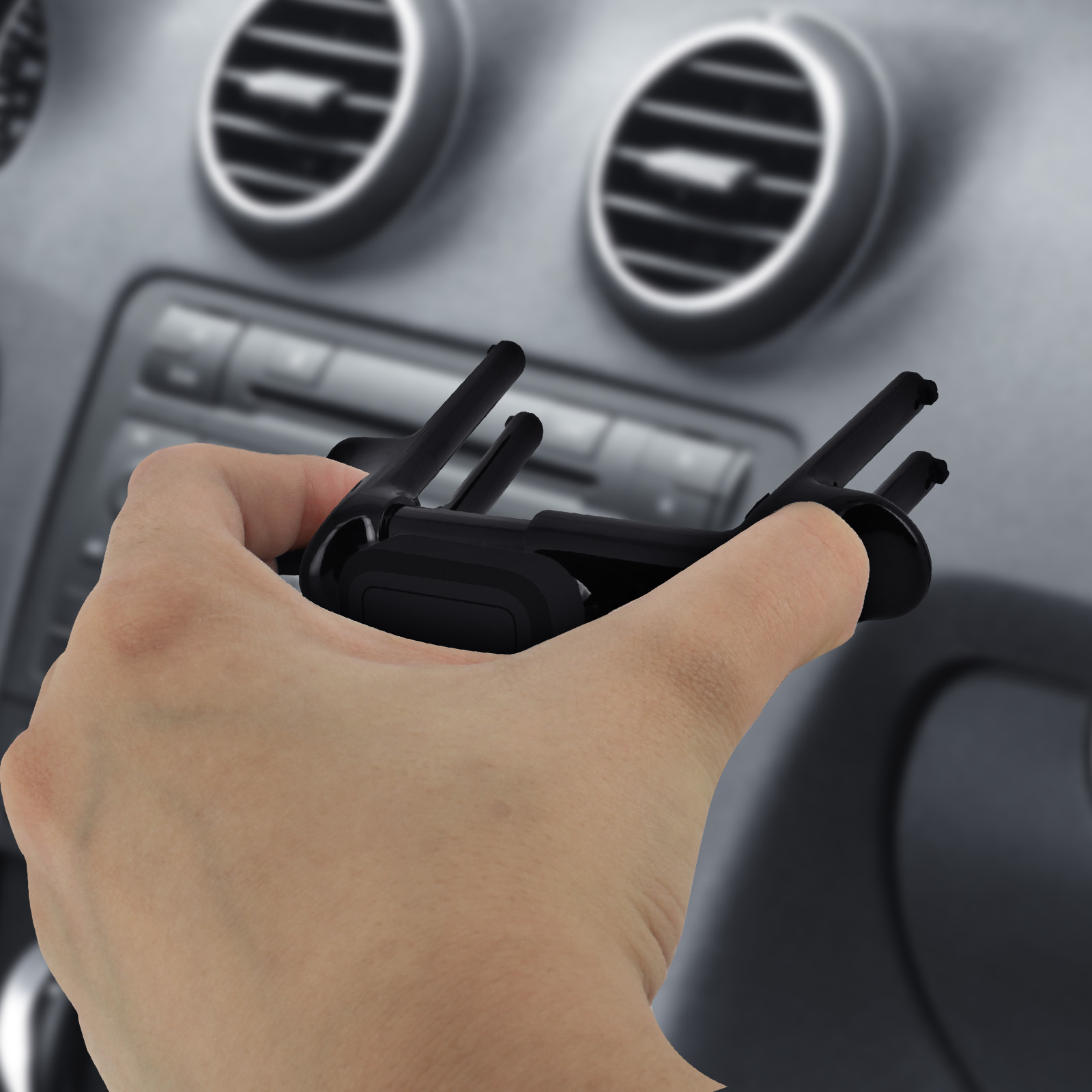 Hand hält eine schwarze Autotelefonhalterung. Hintergrund zeigt Autointerieur mit Luftauslässen.
