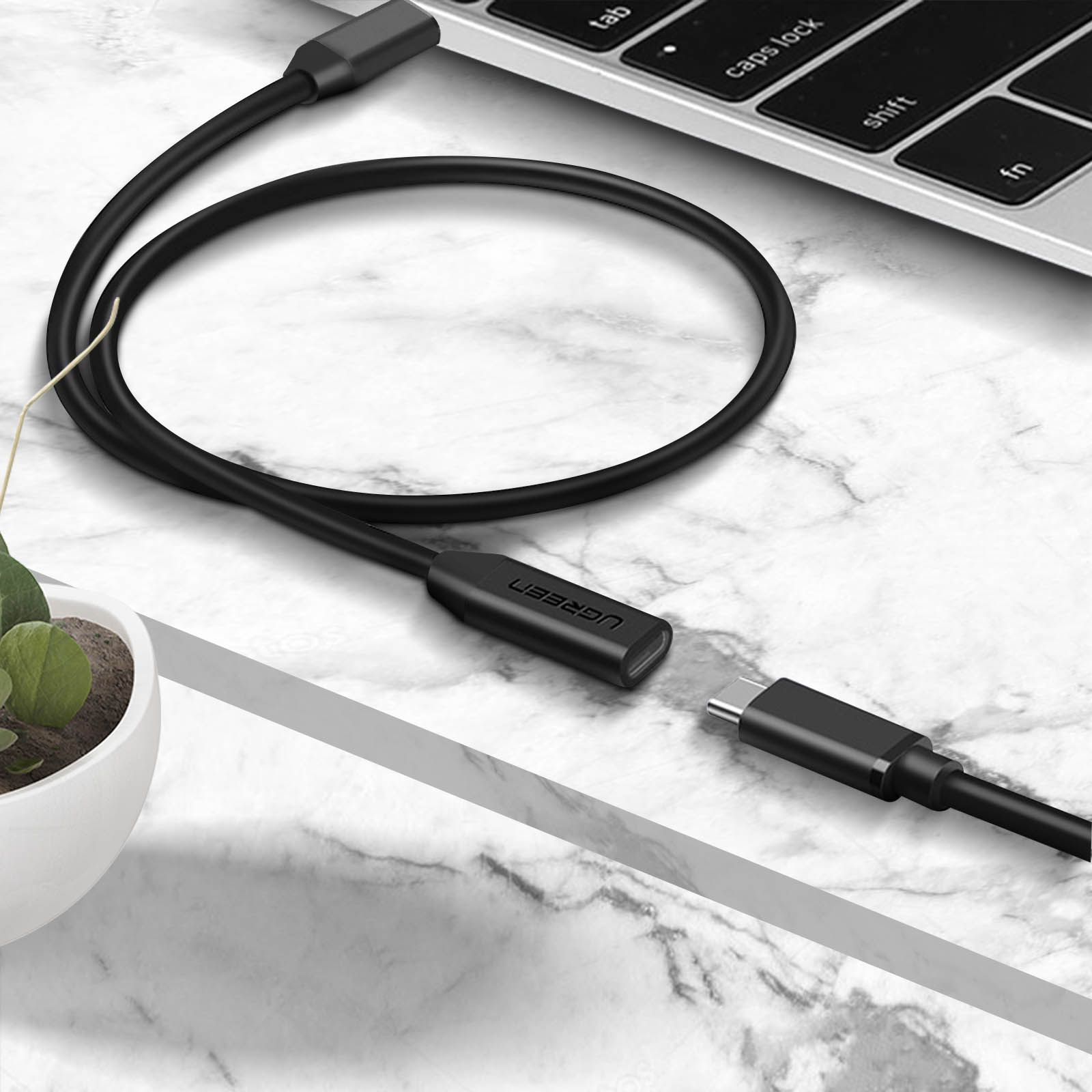 USB-C-kabel aangesloten op een laptop en een UGREEN-adapter.