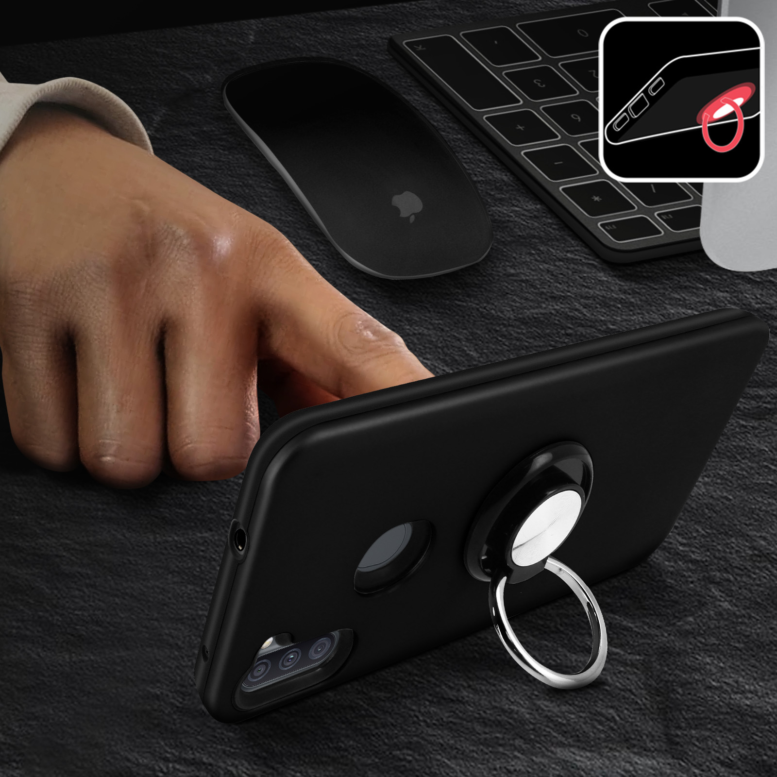 Hand hält ein schwarzes Telefon mit Ringhalter. Maus und Tastatur im Hintergrund.