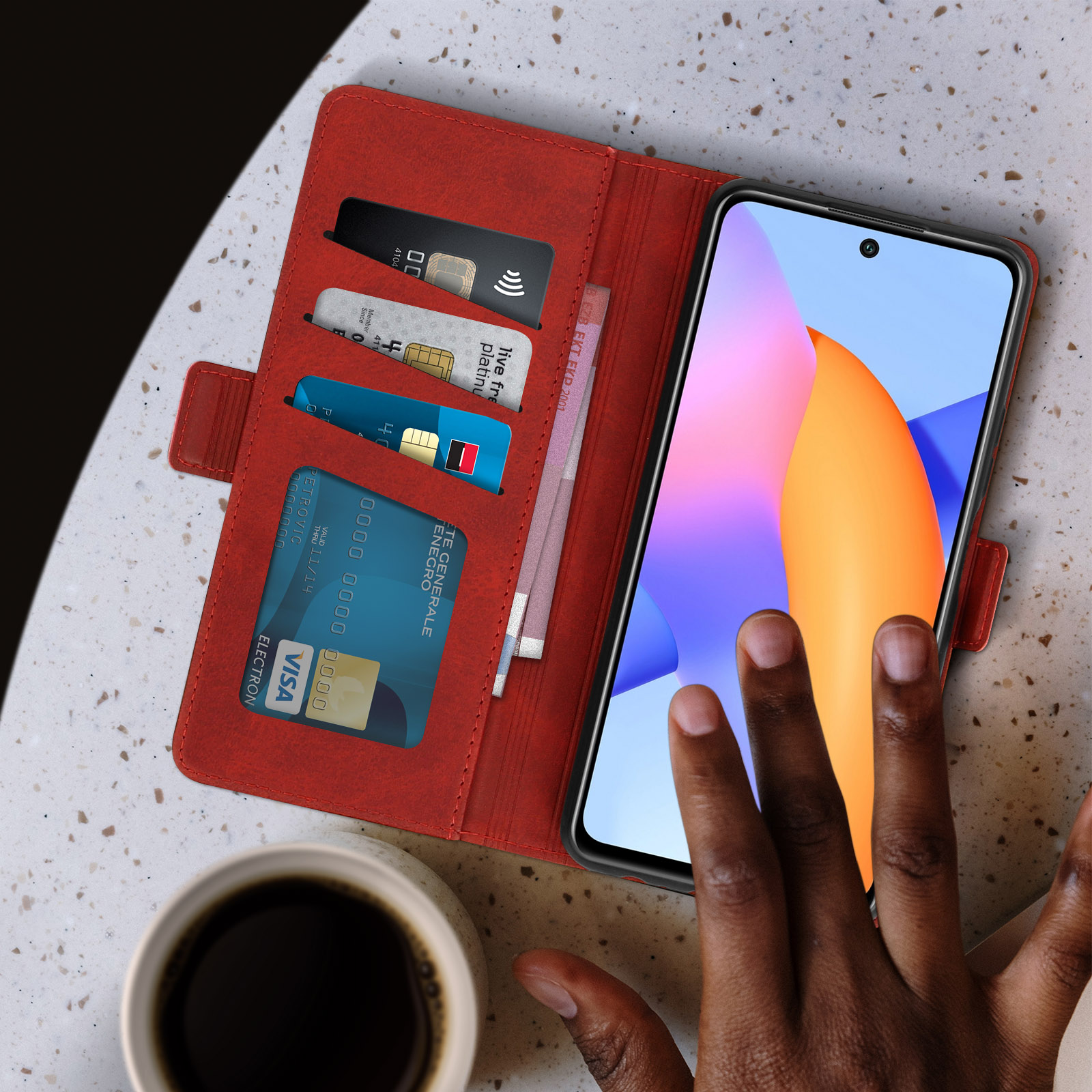 Rote Handyhülle mit Telefon. Kreditkarten im Case. Kaffeetasse daneben.