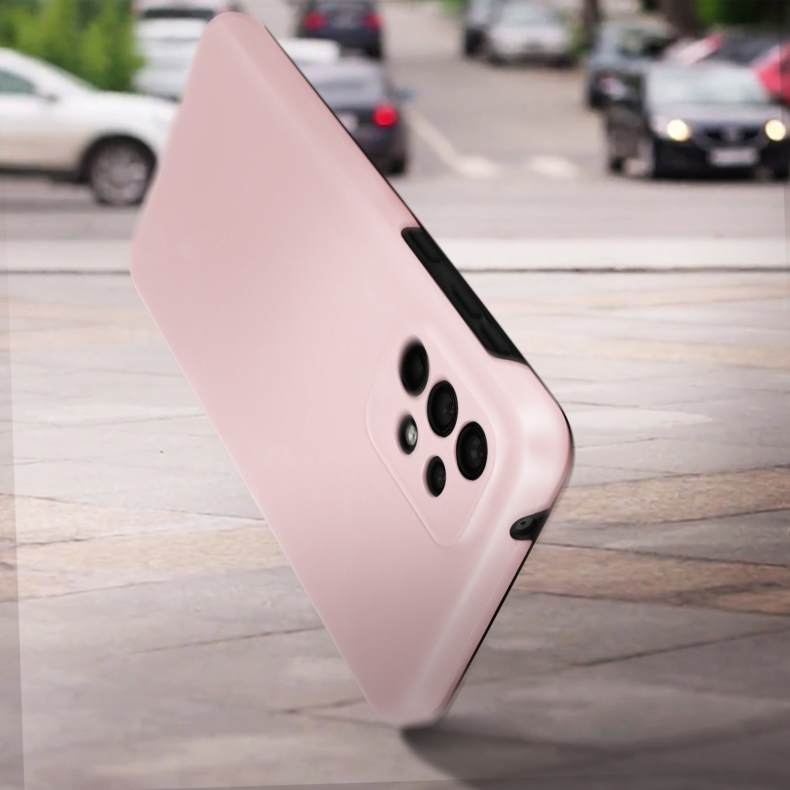 Coque de téléphone rose avec une bosse de caméra, dans un cadre extérieur avec des voitures en arrière-plan.