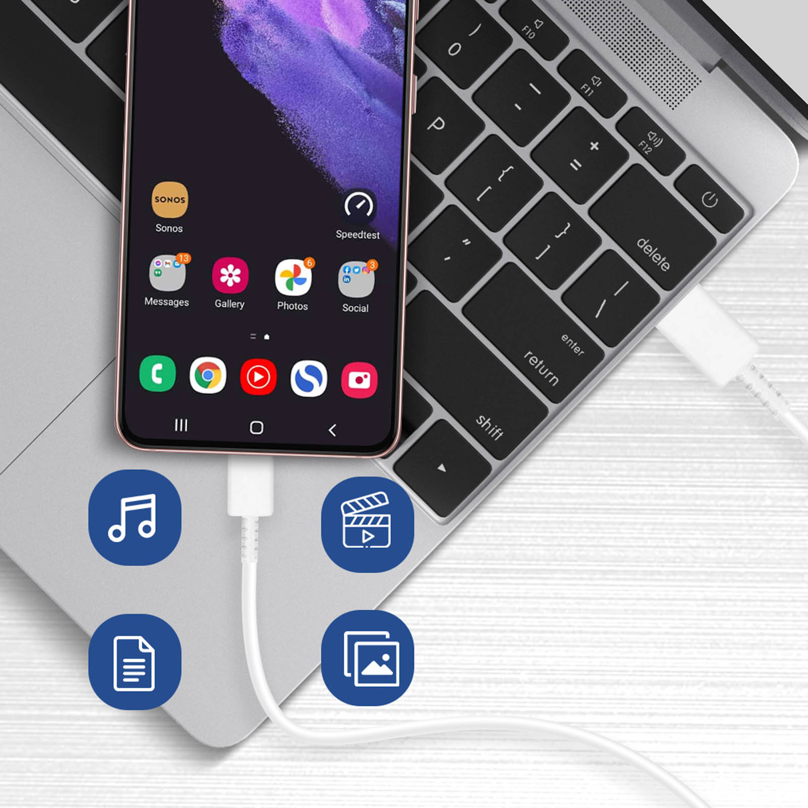 Un telefono collegato a un laptop con un cavo bianco, che mostra icone di app sullo schermo.