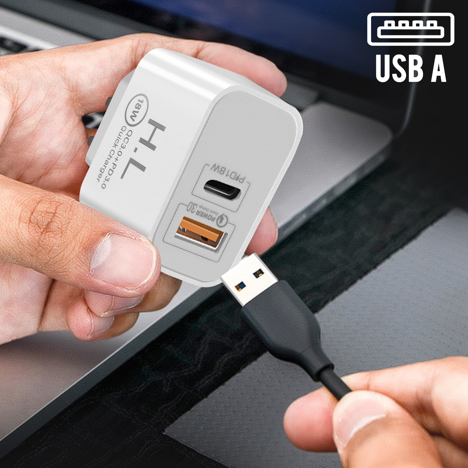 Hand hält weißes Ladegerät mit USB-Kabel, das an einen Laptop angeschlossen ist.