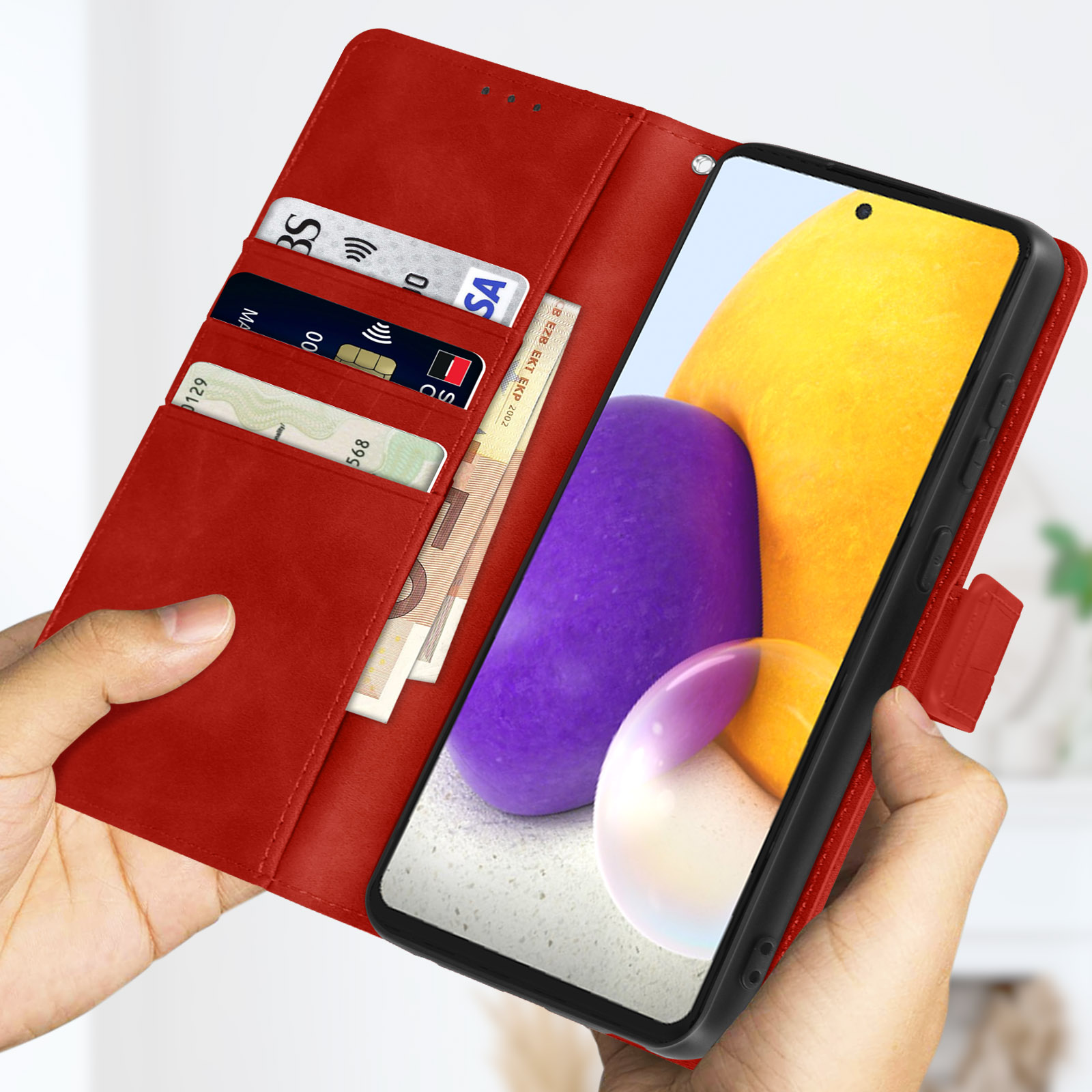 Custodia rossa per telefono aperta con telefono, carte e contanti visibili. Tenuta da mani. Sfondo sfocato.