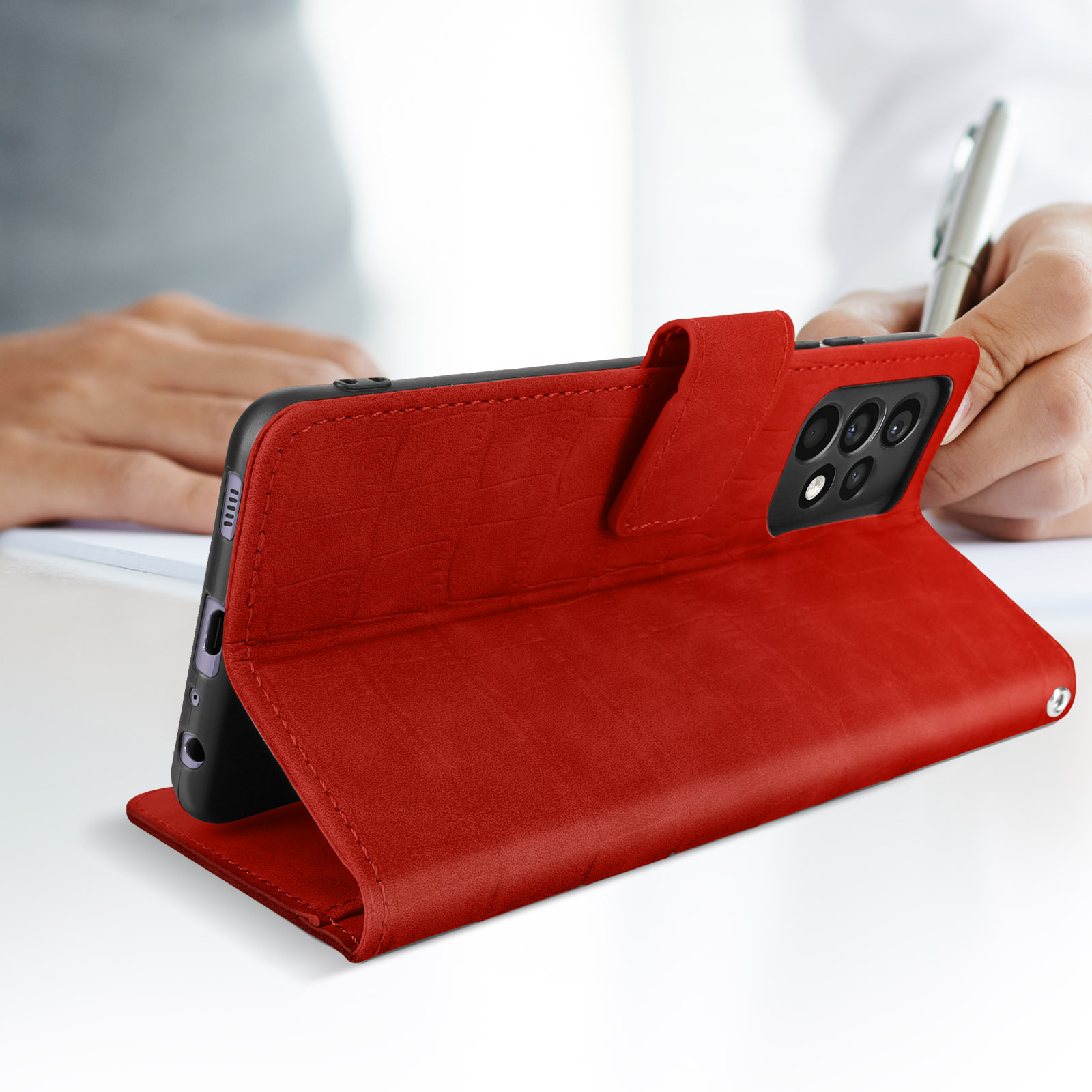 Custodia rossa con telefono dentro, appoggiata su una scrivania.
