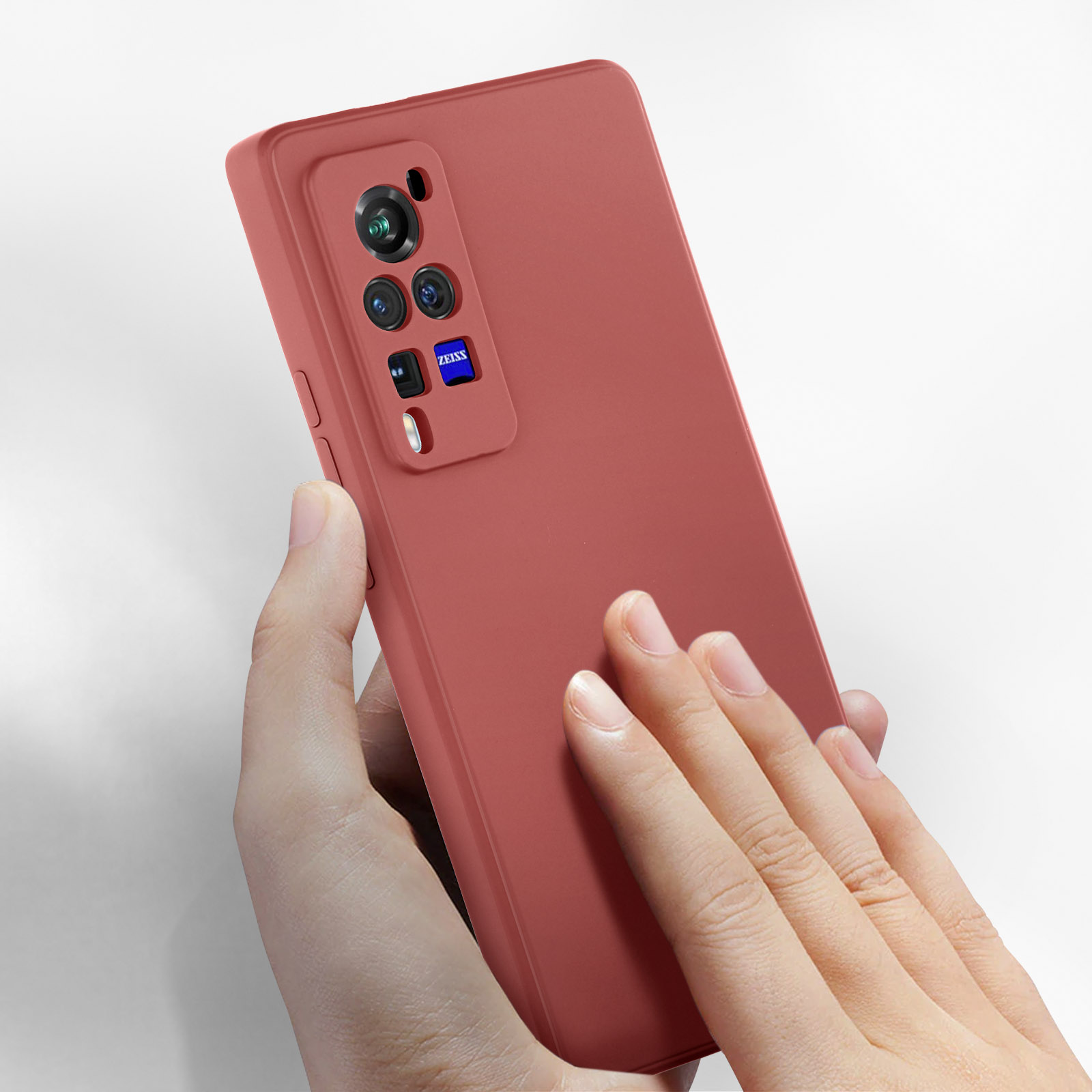Custodia per telefono rossa tenuta in mano. La custodia ha un ritaglio per la fotocamera, con logo ZEISS.