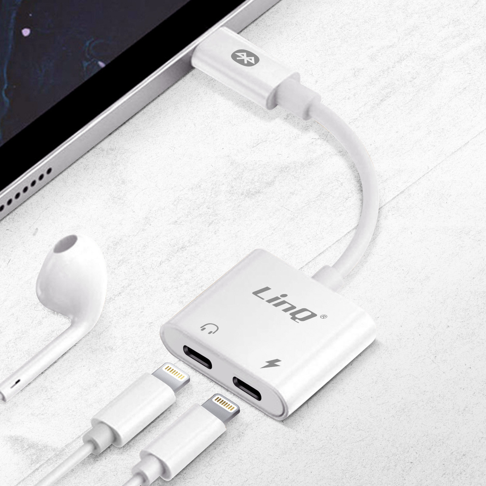 Weißer Adapter mit mehreren Anschlüssen und Kabeln. Anschluss an ein Tablet und ein Paar Kopfhörer.