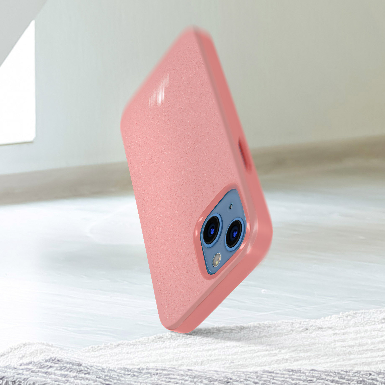 Una custodia per telefono rosa con una fotocamera, in piedi su una superficie.
