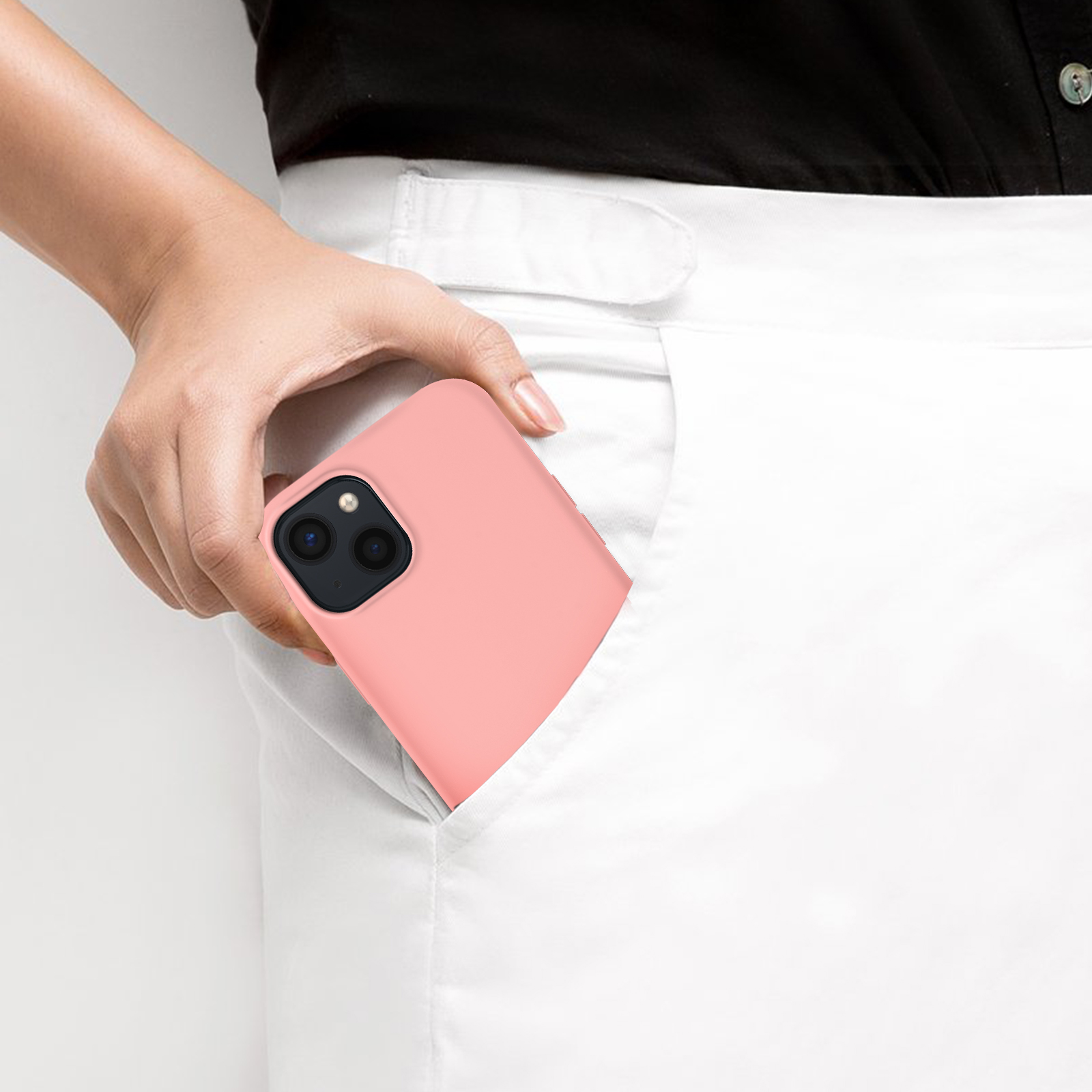 La mano di una persona che mette una custodia per telefono rosa chiaro in tasca.