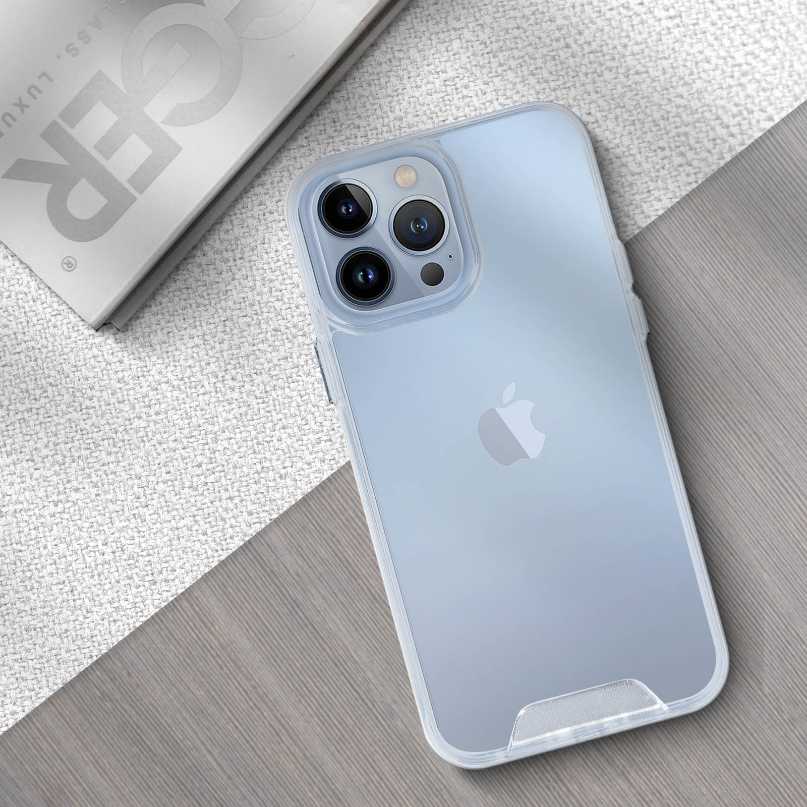 Custodia trasparente su un telefono, con logo Apple. Il telefono è su una superficie di legno, con un libro.