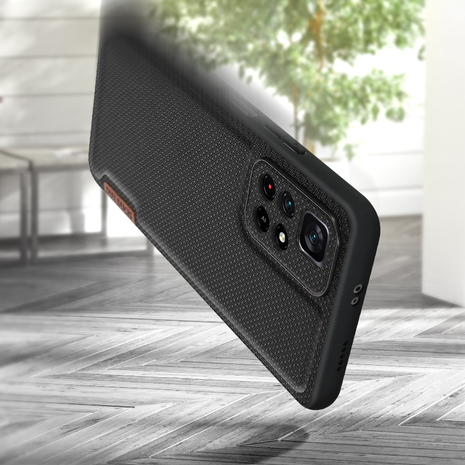 Custodia per telefono nera con design strutturato e rialzo della fotocamera. Sfondo del pavimento in legno.