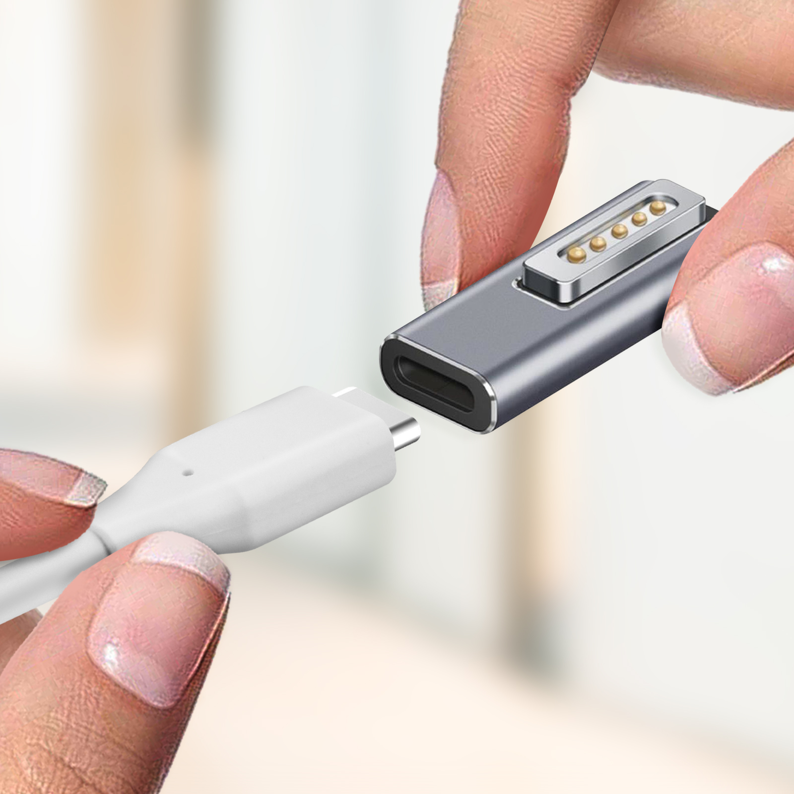 Hände verbinden ein USB-C-Kabel mit einem magnetischen Adapter.