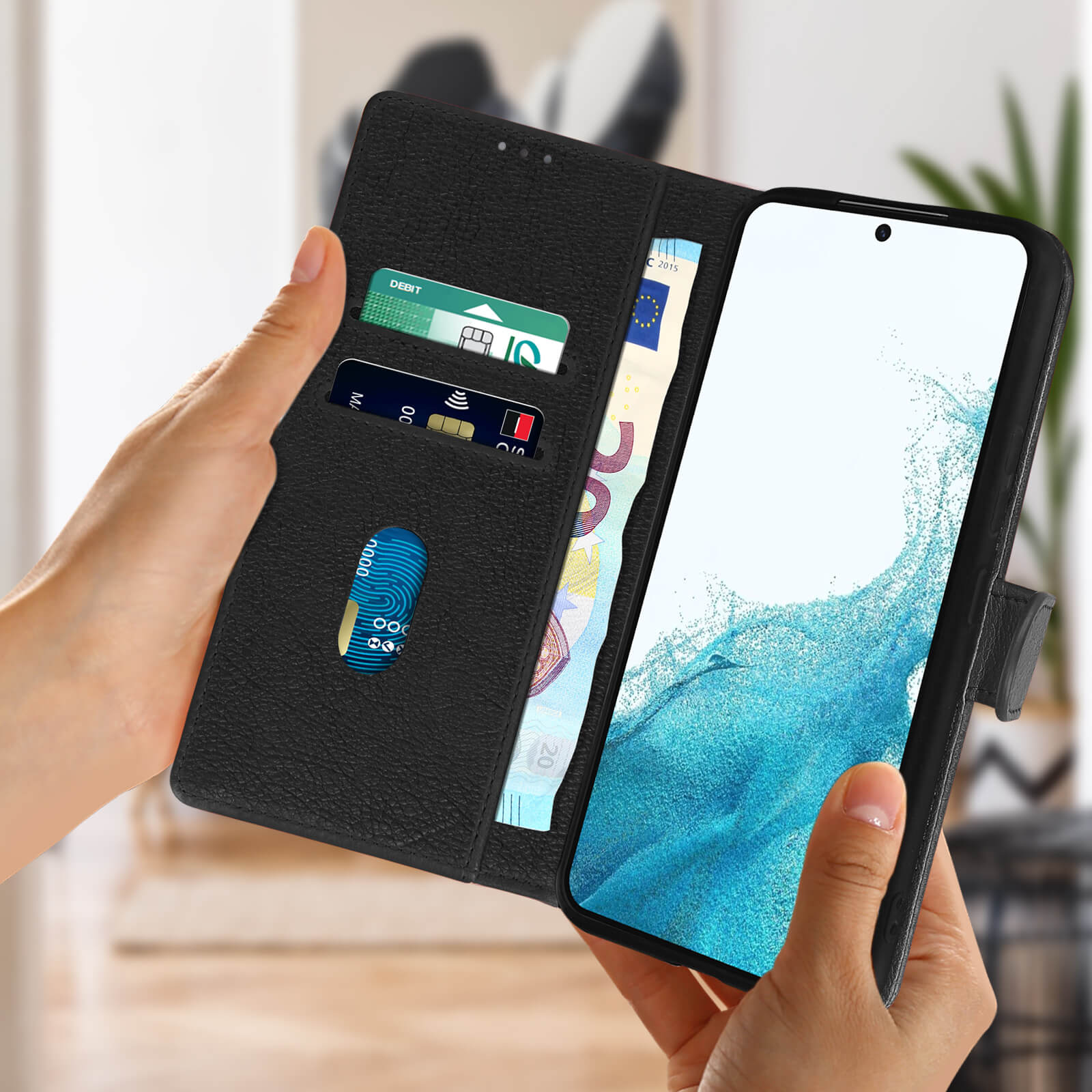Une personne tenant un étui de téléphone noir ouvert avec des cartes de crédit et de l'argent liquide. Le téléphone a un écran bleu.