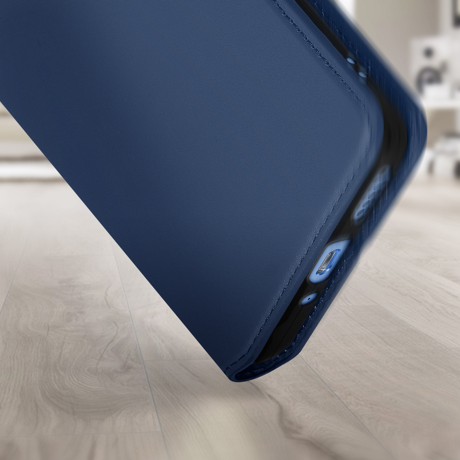 Close-up van een marineblauwe telefoonhoes op hout, met textuur en ontwerpdetails.
