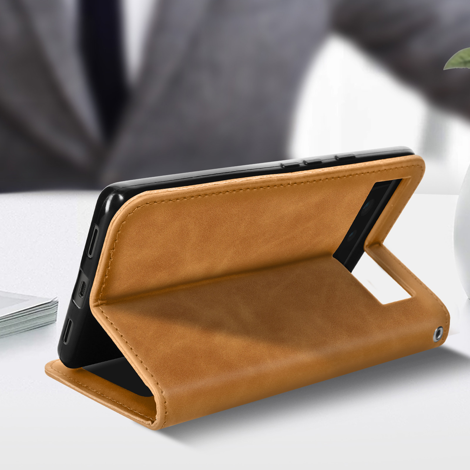 Telefoon in een bruine leren hoes, open en omhoog gezet, op een neutrale achtergrond.