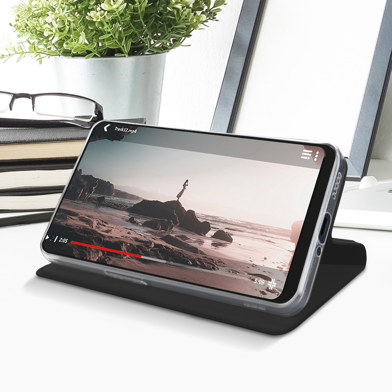 Un telefono mostra un video. Il telefono è su un supporto, su un tavolo.
