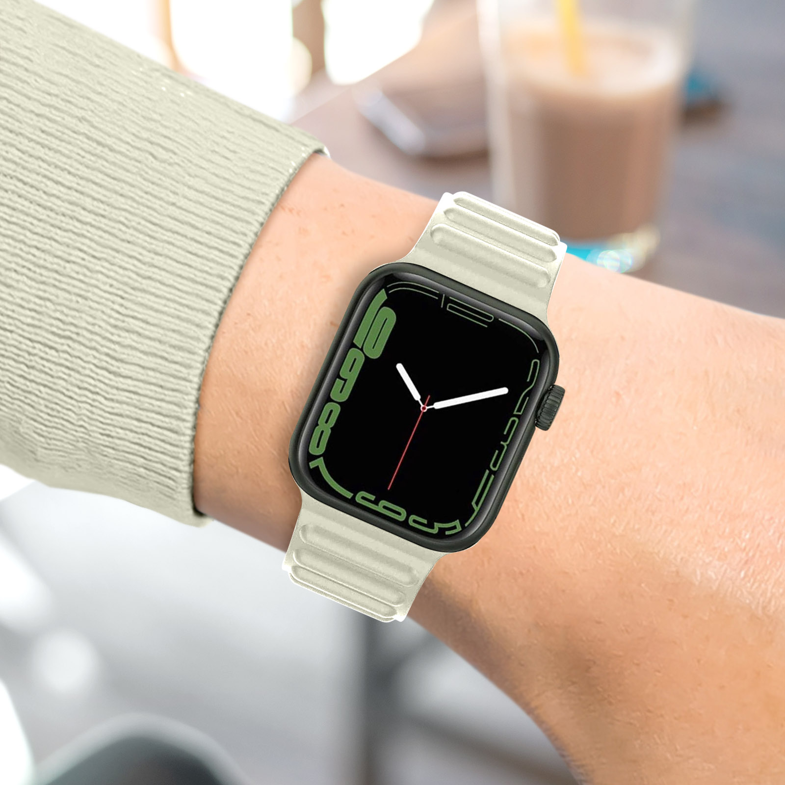 Una persona usando un smartwatch con correa blanca.