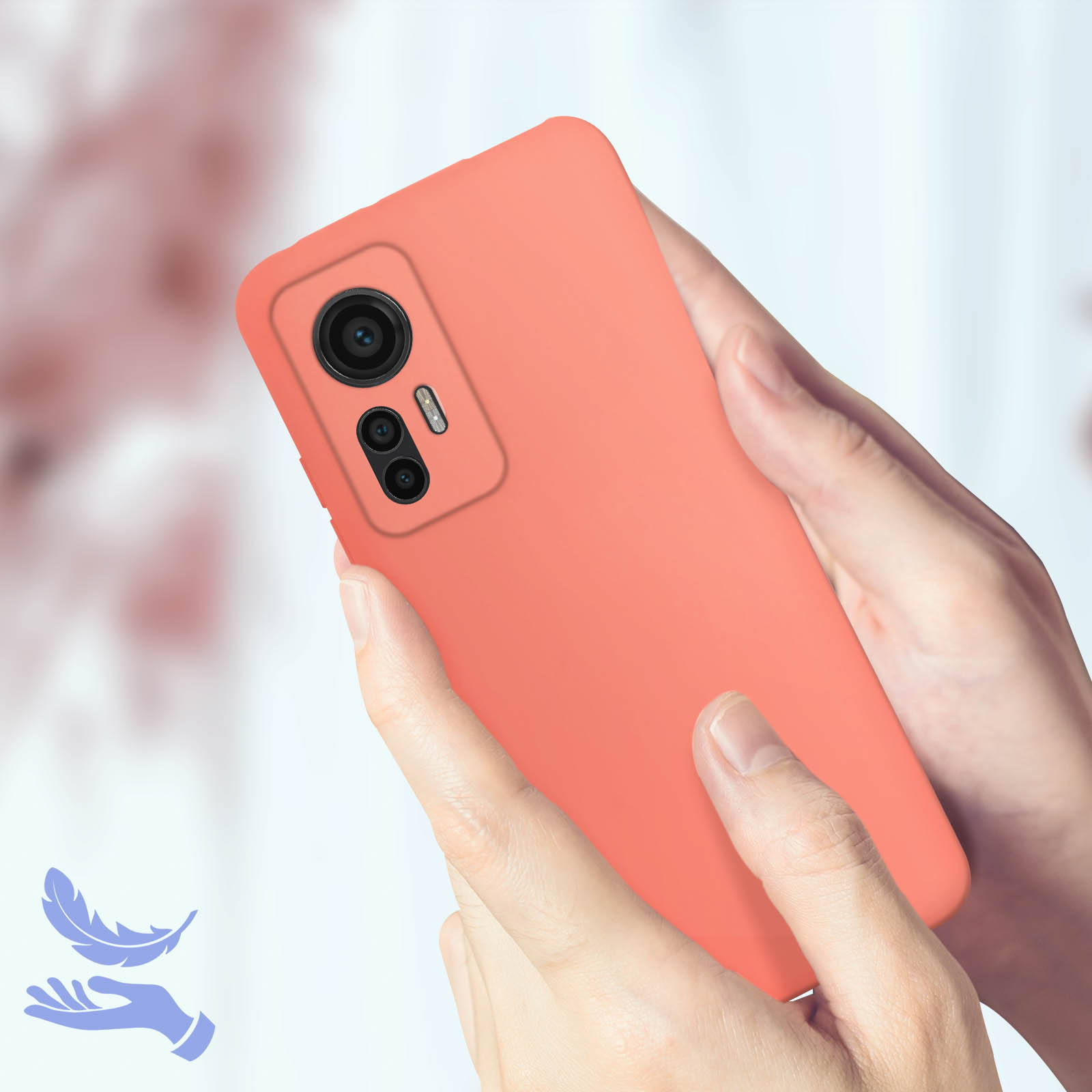 Mani che tengono una custodia per telefono corallo con fotocamera su sfondo sfocato.