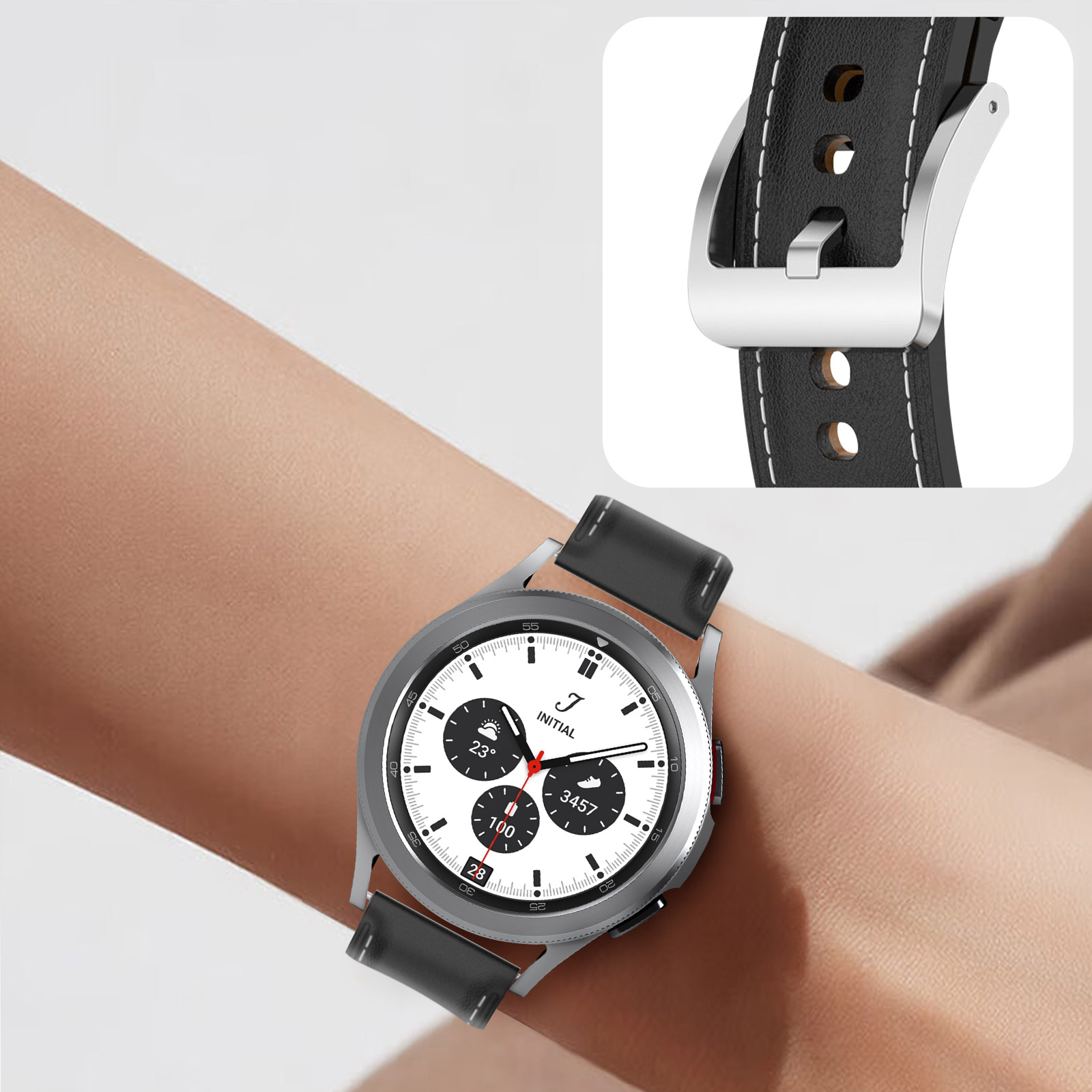 Muñeca con reloj. El reloj es plateado con correa de cuero negro y esfera blanca.