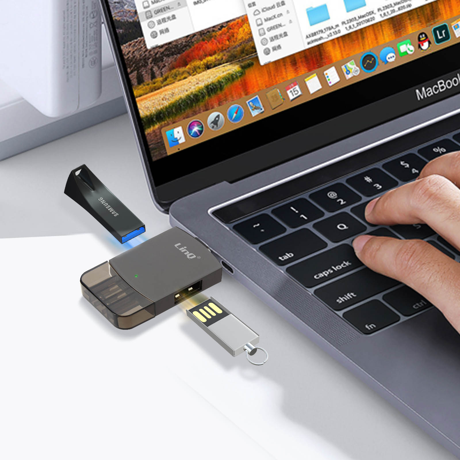 Un ordinateur portable avec des clés USB branchées. Une main pointe vers le clavier. Des câbles sont visibles.