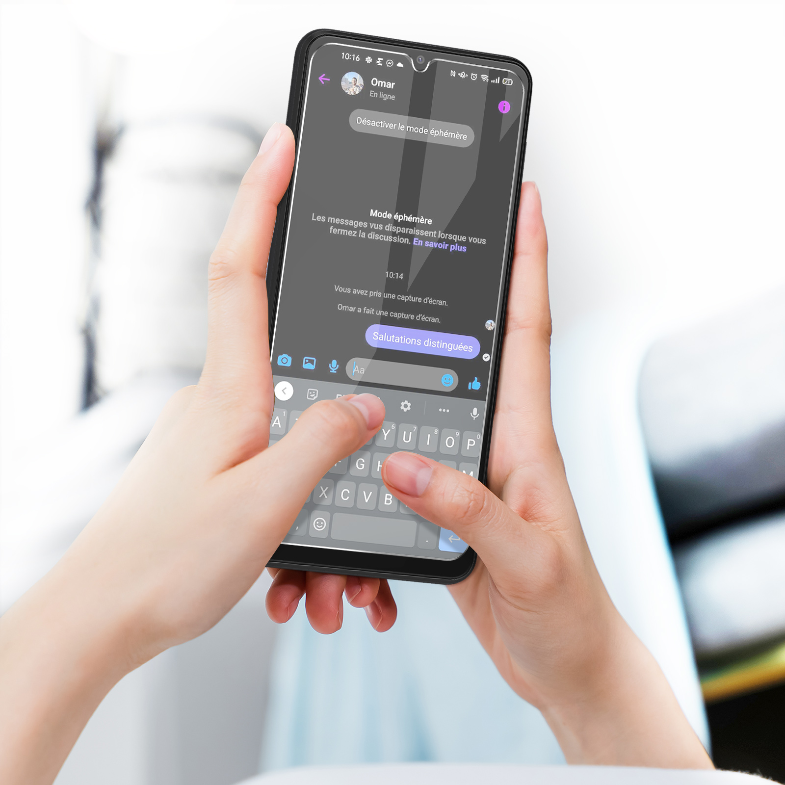 Un telefono in mano, che mostra una schermata di chat. Lo schermo mostra messaggi di testo.