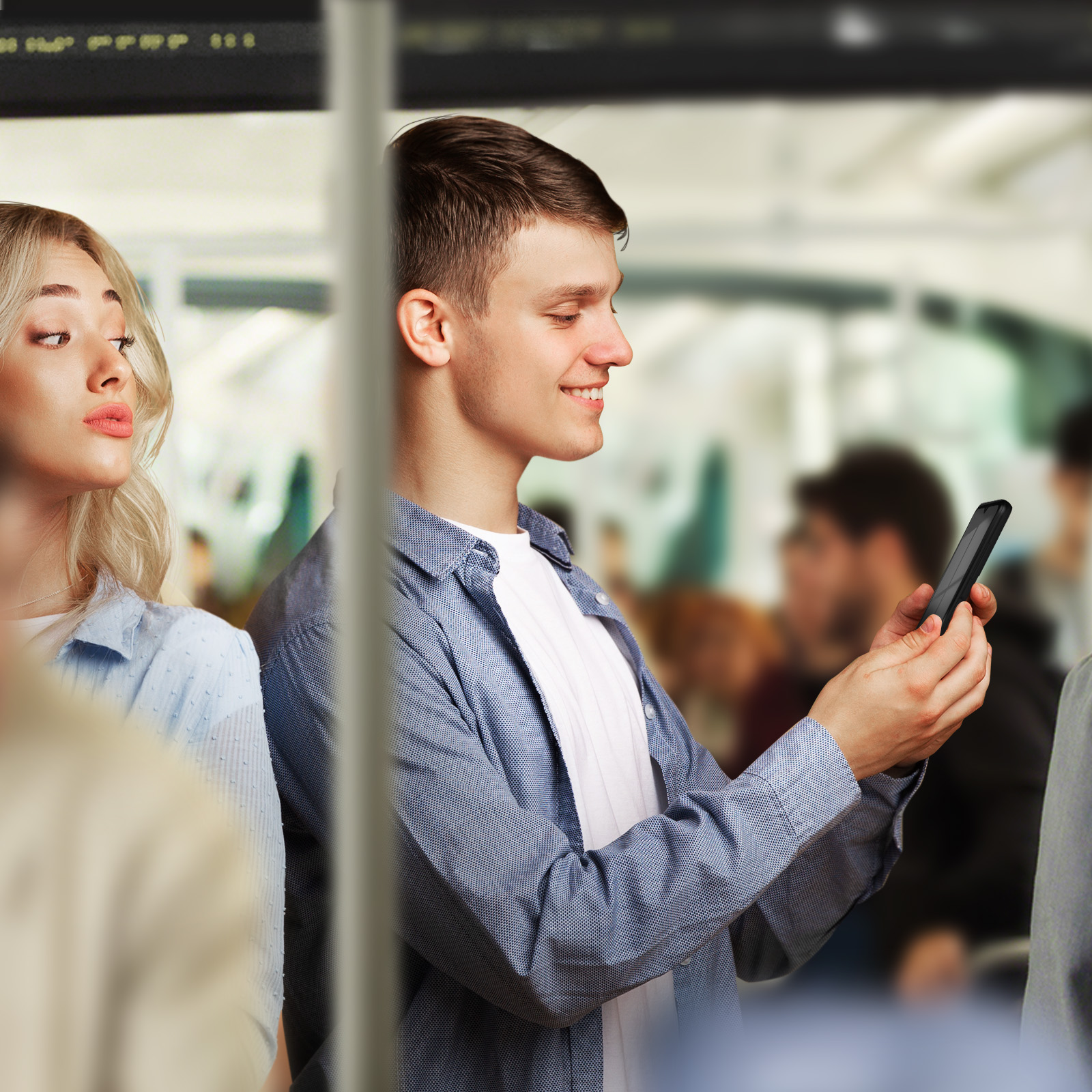 Homme utilisant un téléphone dans le métro, femme blonde regarde, arrière-plan flou.