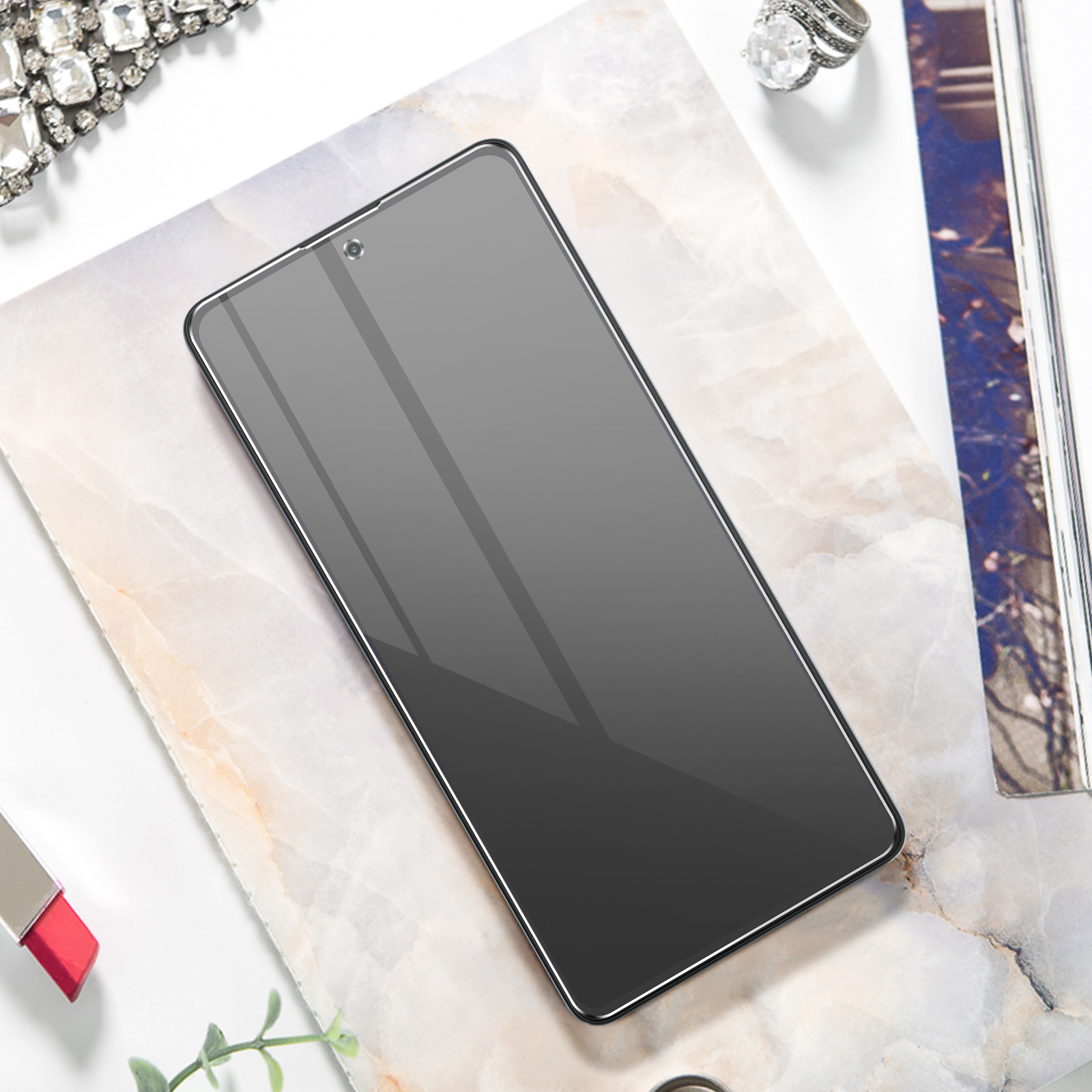 Un écran de téléphone avec un dégradé. Le téléphone est sur une surface en marbre. Il y a des accessoires à proximité.