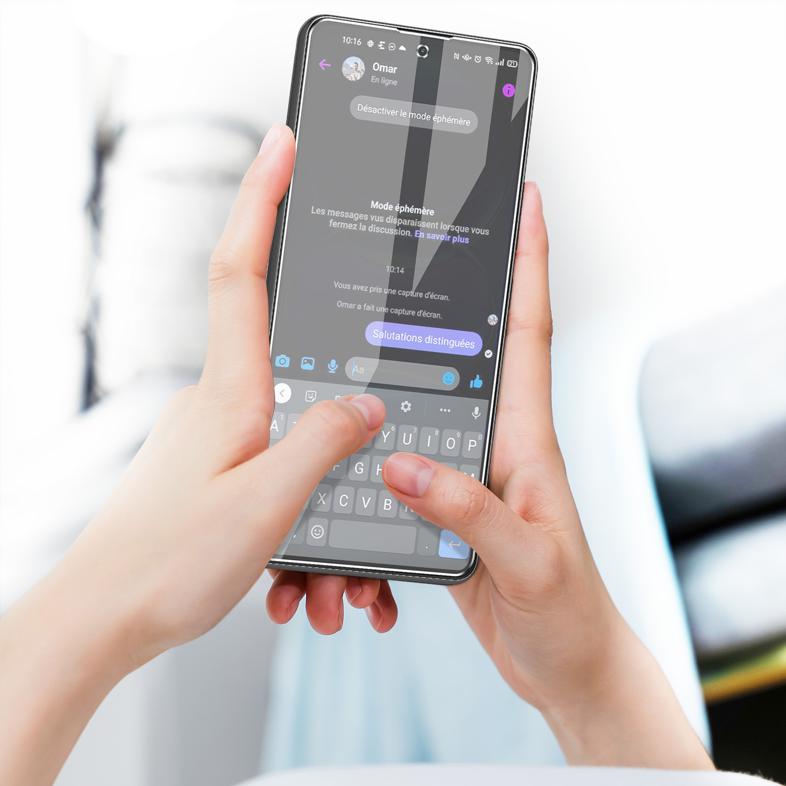 Un téléphone en main, affichant un écran de chat. L'écran affiche des messages texte.