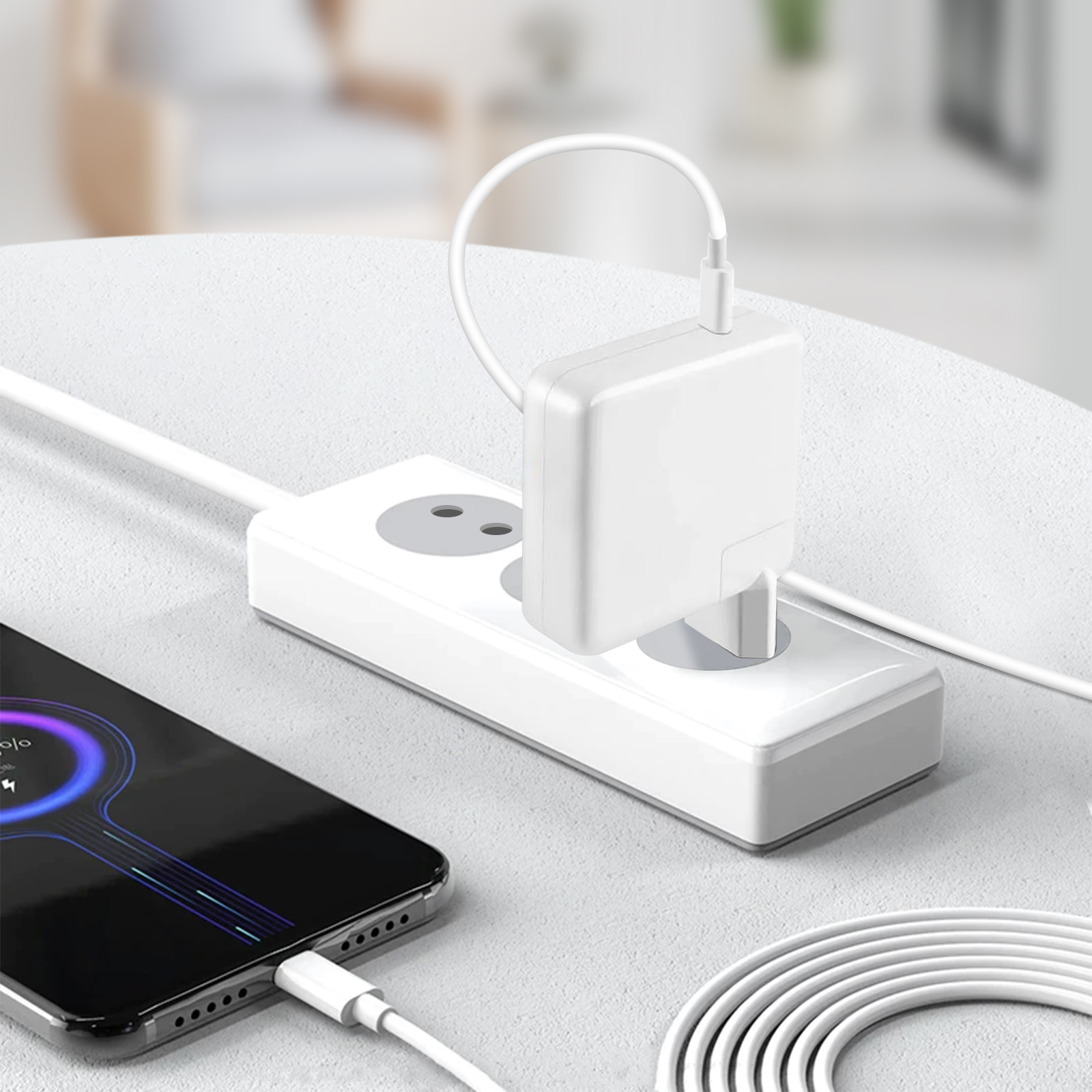 Teléfono cargando. El teléfono tiene un logo de carga. Cargador blanco y regleta en mesa blanca.
