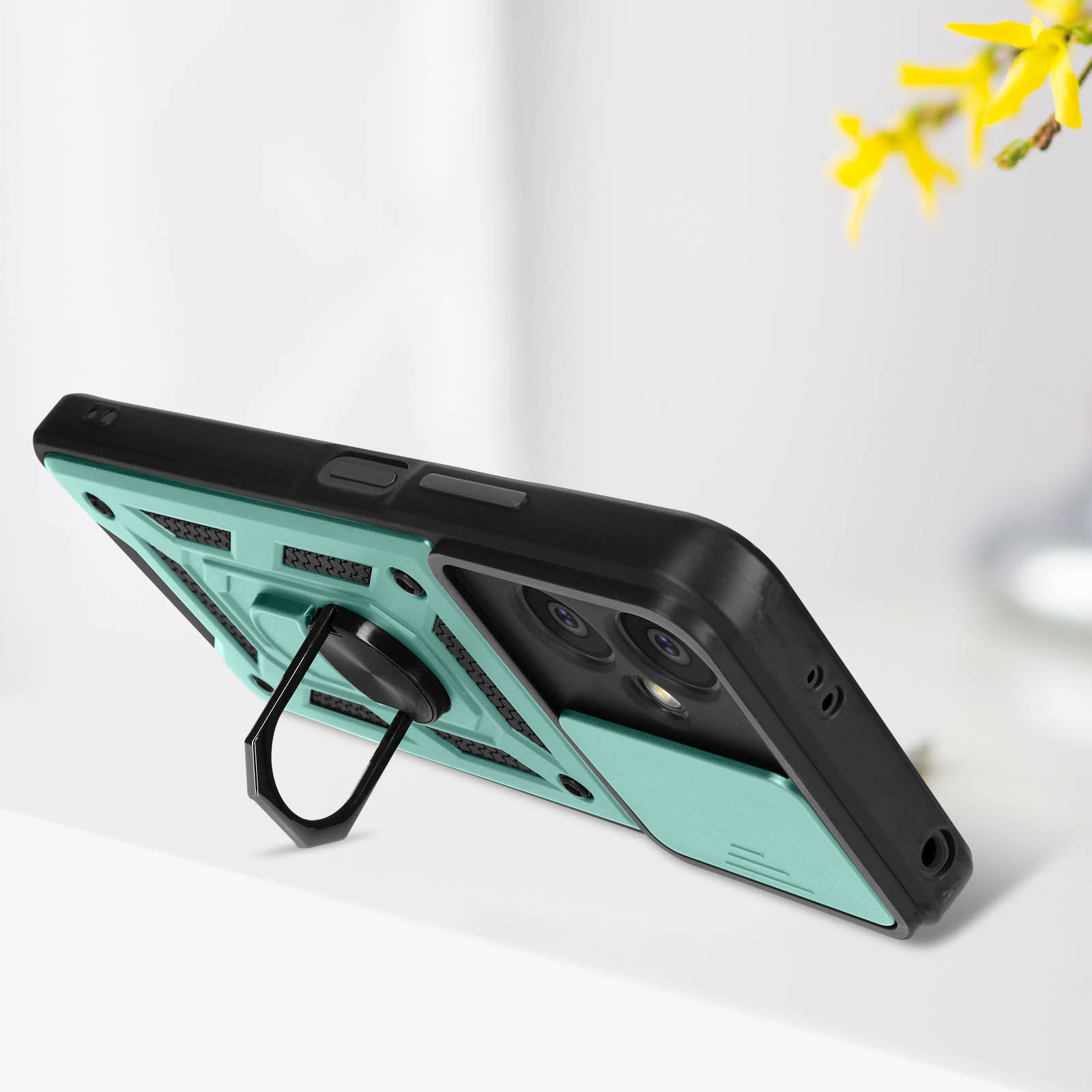 Una custodia per telefono con un anello di supporto, su una superficie bianca. La custodia è nera e verde acqua.