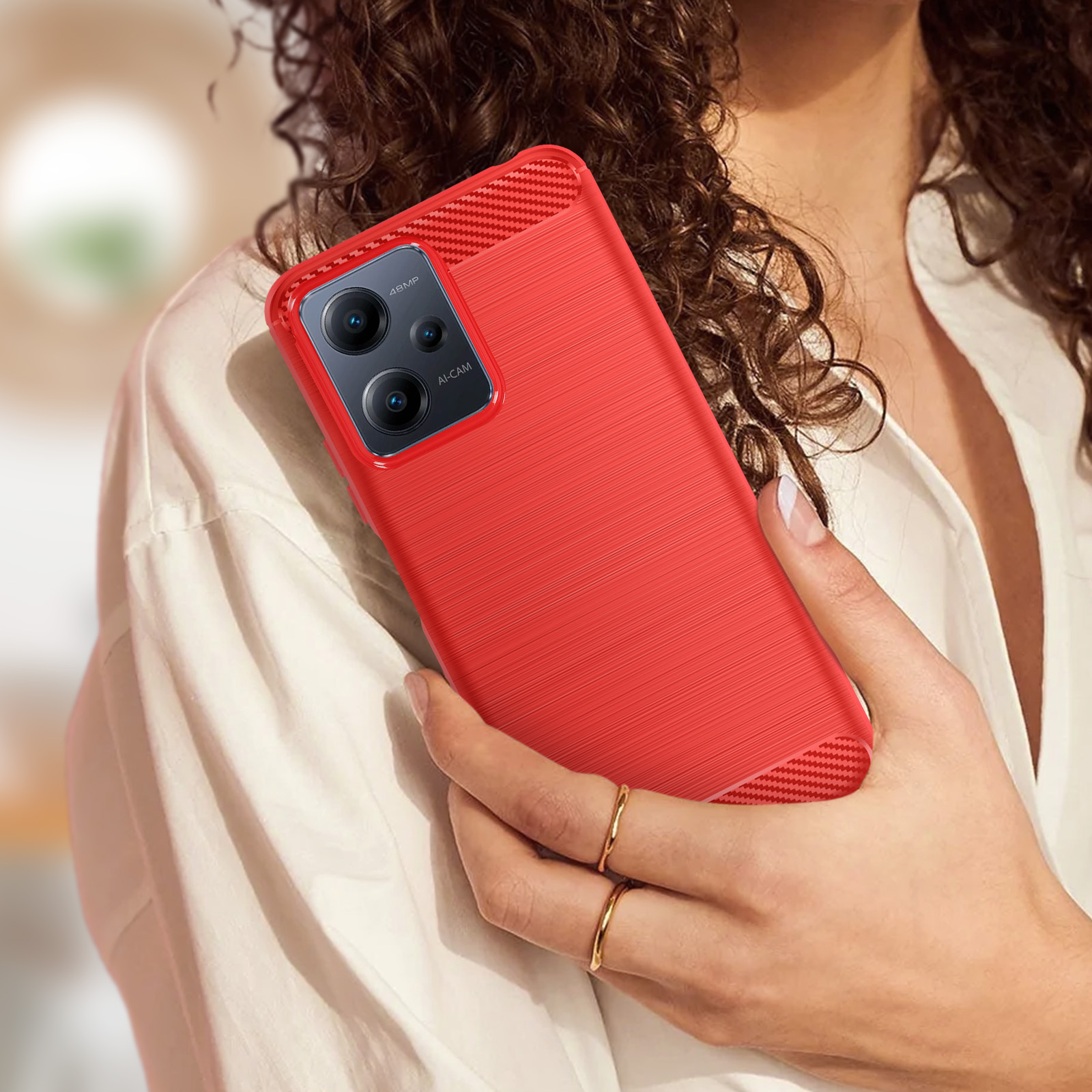Una donna che tiene una custodia rossa per telefono con un design strutturato, con fotocamera sul retro.