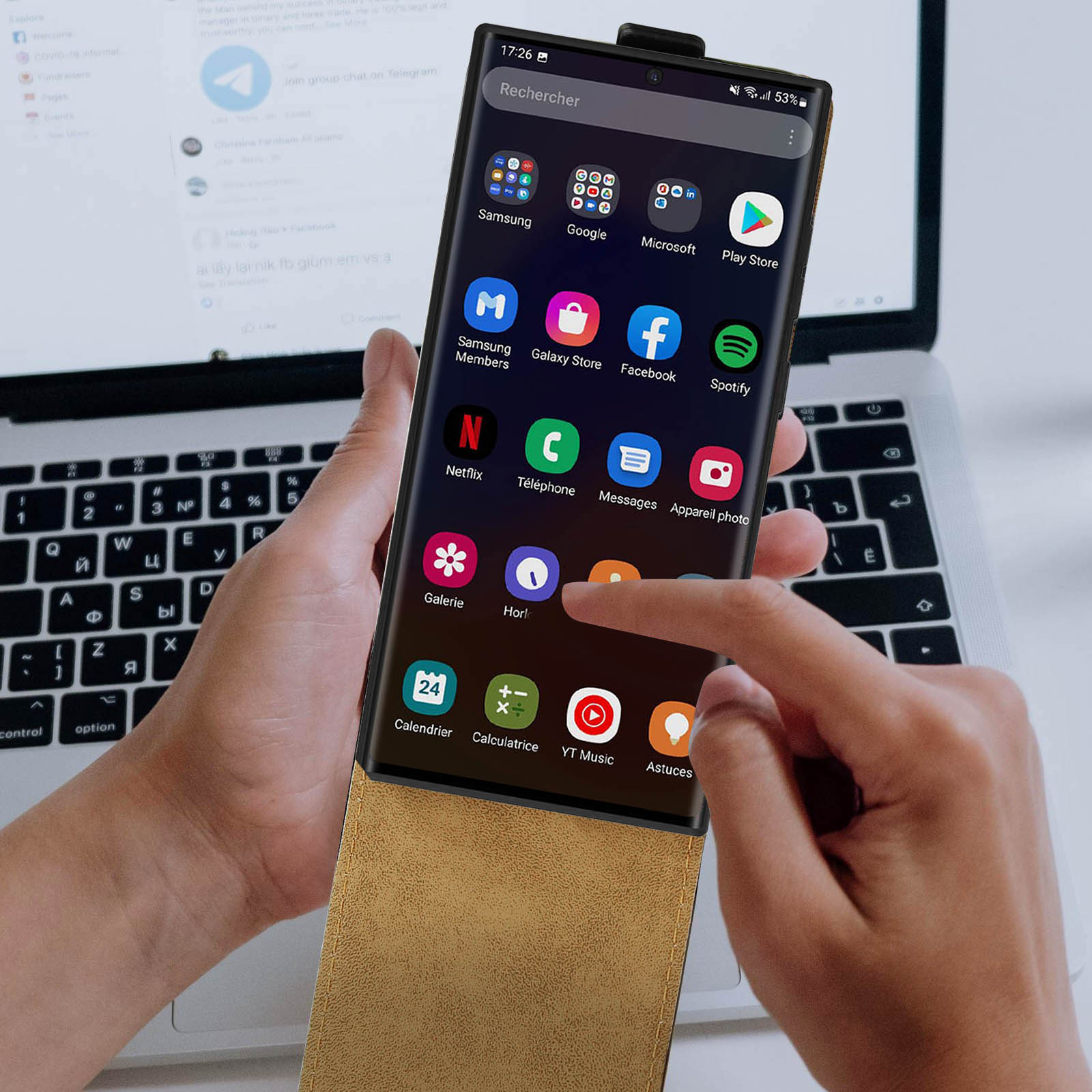 Een hand van een persoon die een telefoonscherm aanraakt met app-pictogrammen en een zoekbalk.