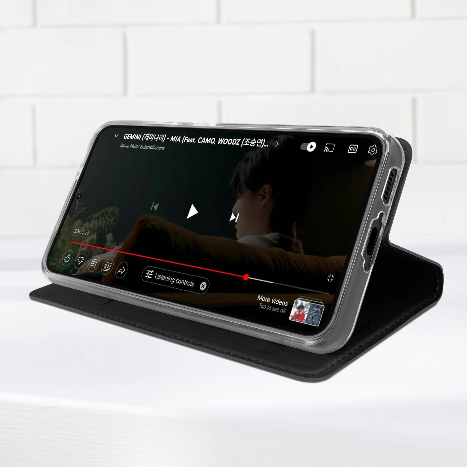 Ein Telefon spielt ein Video auf einer schwarzen Hülle ab. Das Video hat ein Musikvideo.