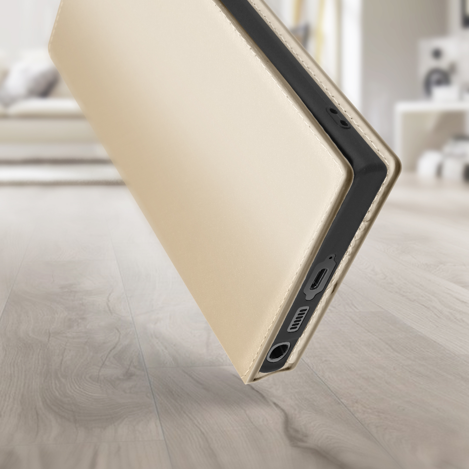Gouden telefoonhoes gedeeltelijk open, de zijkant met poorten en een houten oppervlak tonend.