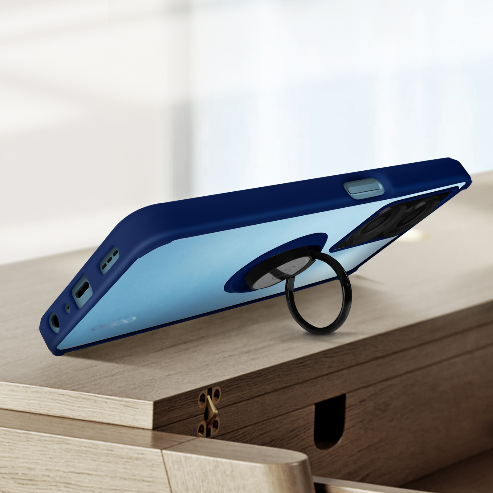 Un telefono blu con un porta anelli, posizionato su una superficie di legno.