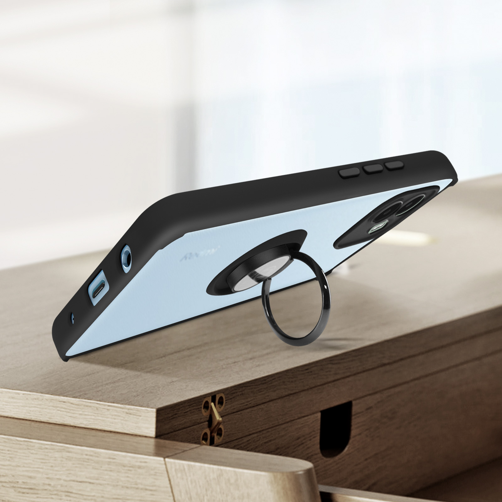 Zwarte telefoonhoes met ringstandaard. De telefoon ligt op een houten oppervlak.